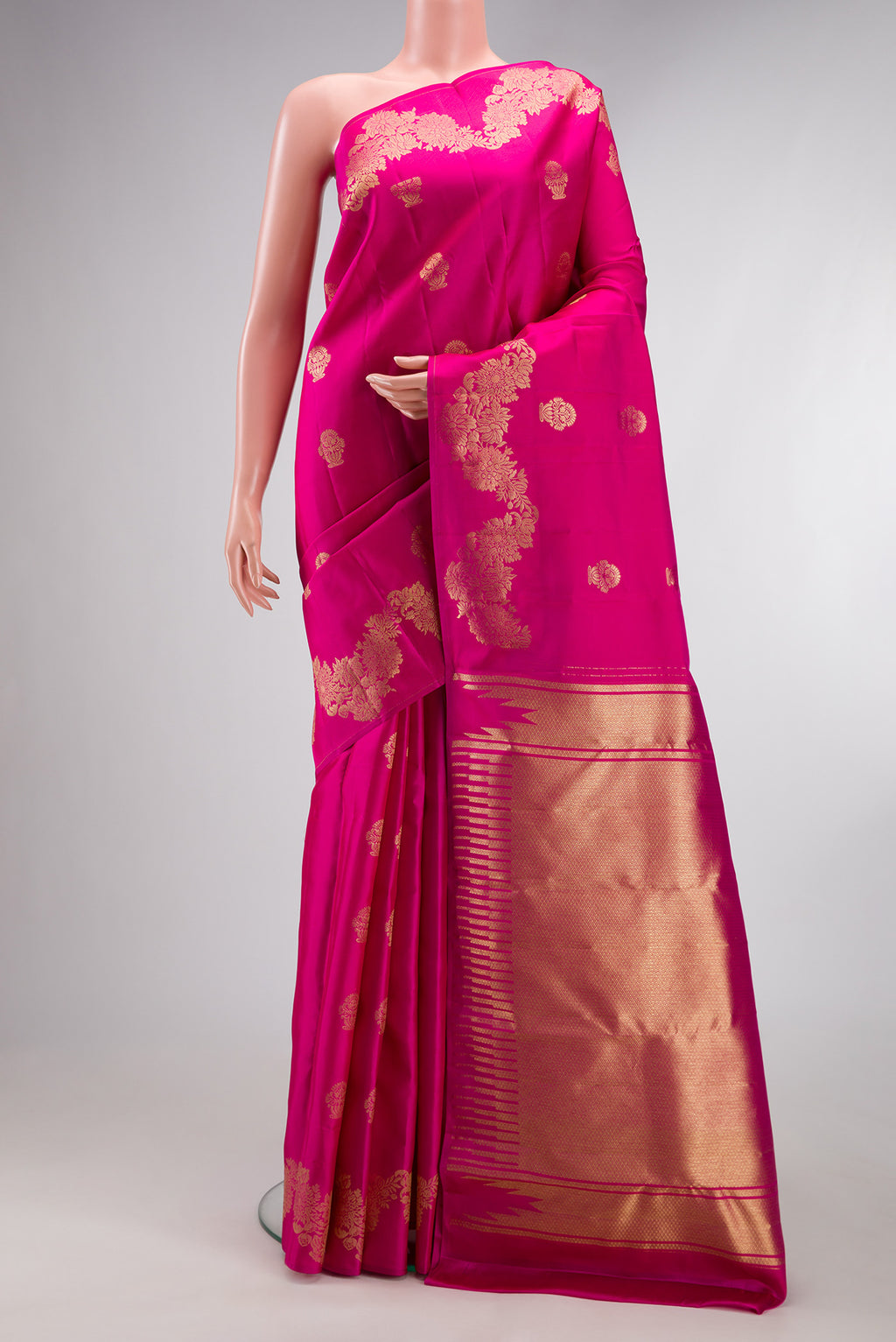 Pure Silk Rani Pink Kanchipuram Saree with Zari Butta on the body and Fancy Border.  displayed on a mannequin