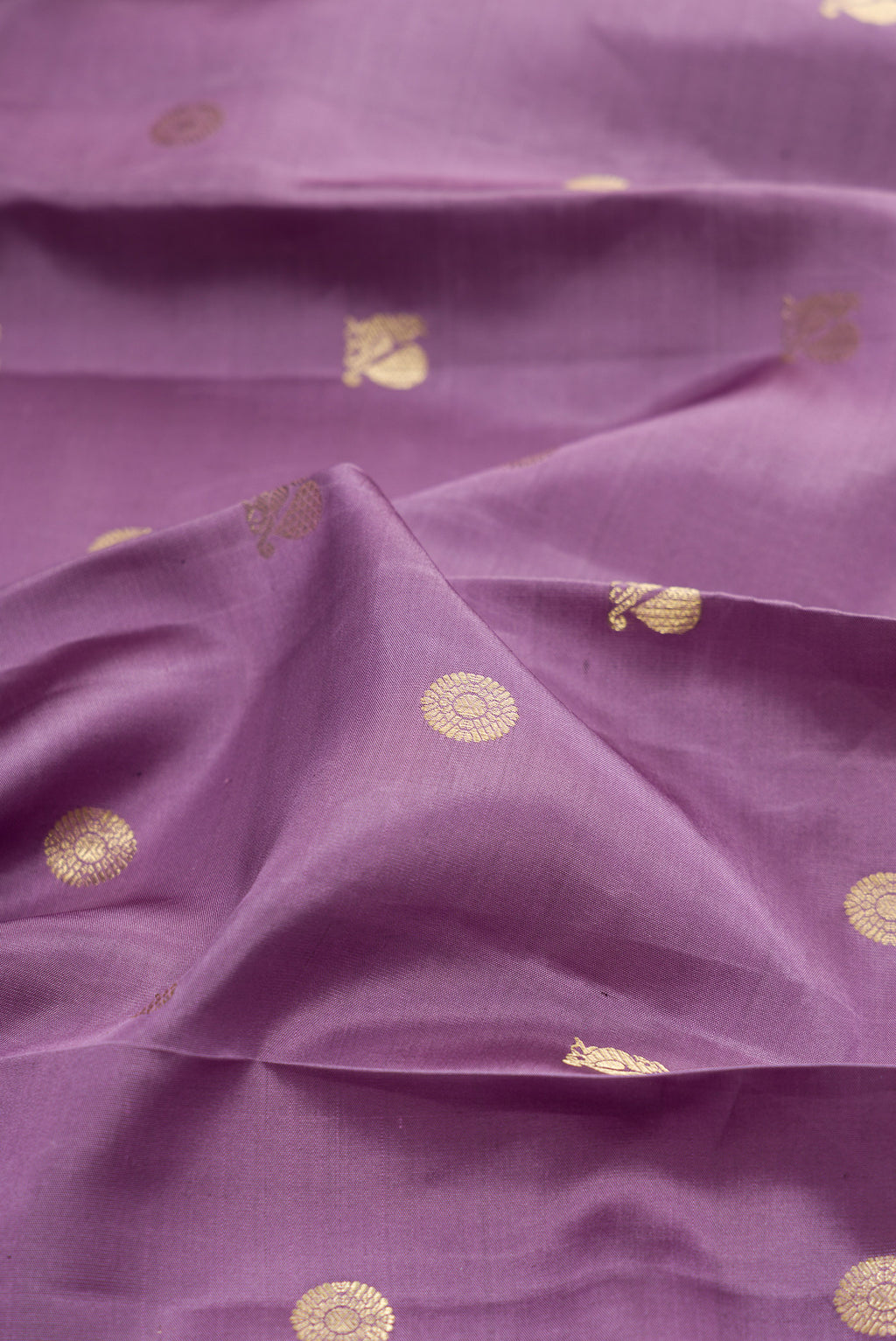 Close up of Lavender Kanchipuram Silk Saree with Zari Butta on the body and Fancy Border.  displaying folds