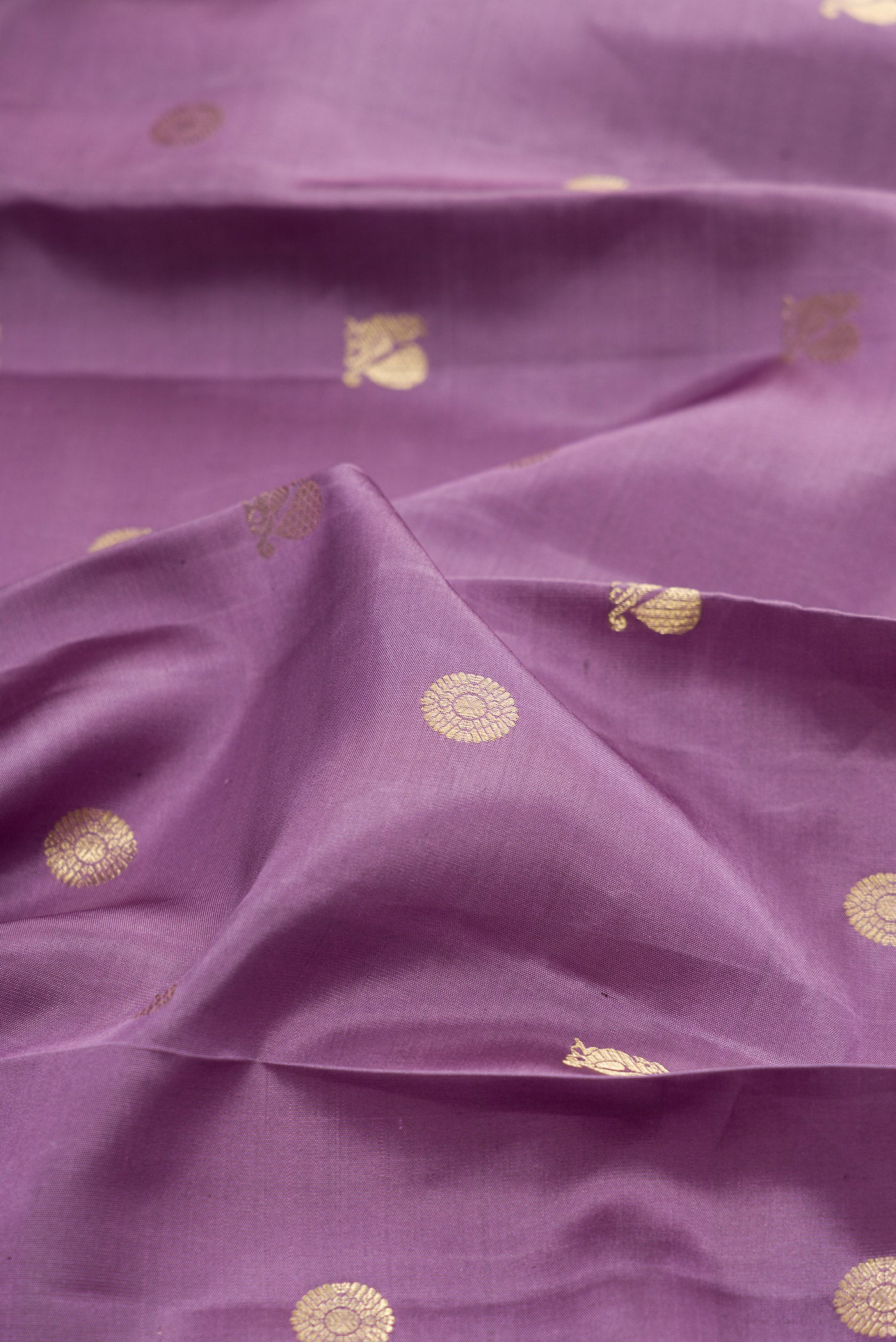 Close up of Lavender Kanchipuram Silk Saree with Zari Butta on the body and Fancy Border.  displaying folds