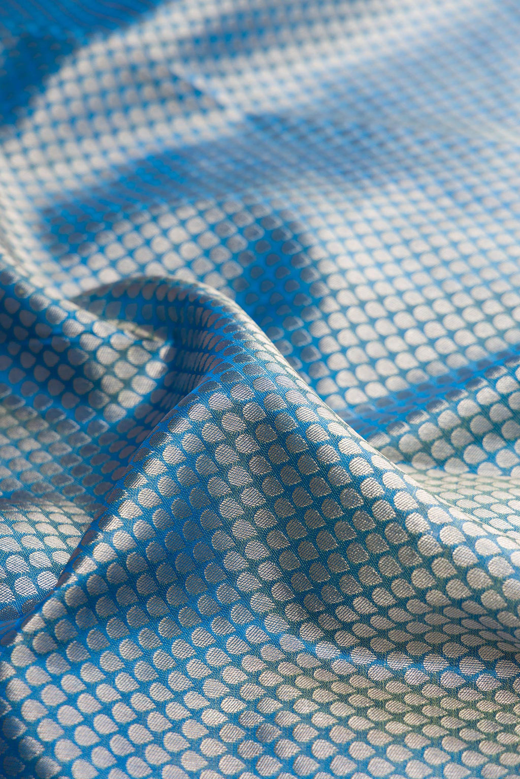 Close up of Pure Silk Peacock Blue Kanchipuram Tissue Saree with Zari Brocade on the body and Fancy Border.  displaying folds
