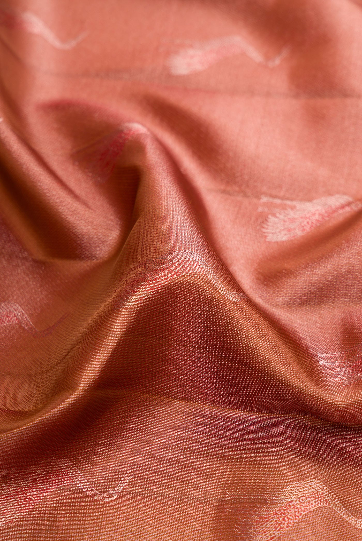 Close up of Rose Gold Dual Tone Kanchipuram Tissue Silk Saree with Zari Brocade on the body and Fancy Border.  displaying folds