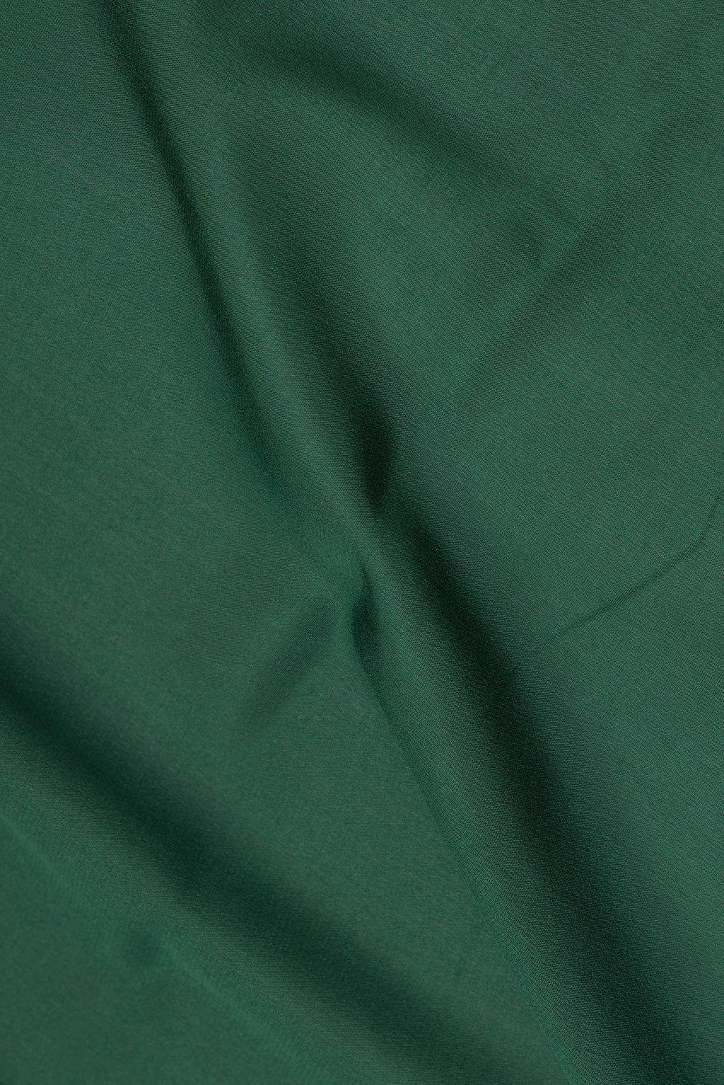 Close up of Bottle Green Mysore Crepe Saree with Plain Body and Zari Border.  displaying folds