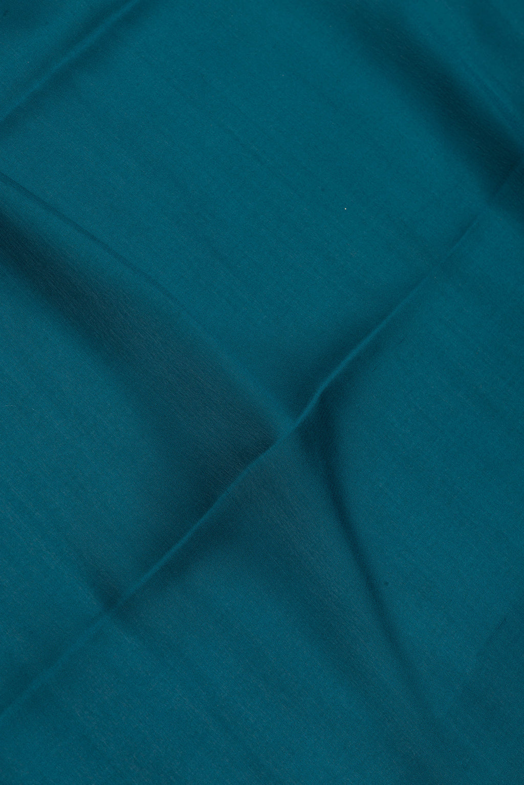 Close up of Peacock Blue Mysore Silk Saree with Plain Body and Zari Border.  displaying folds