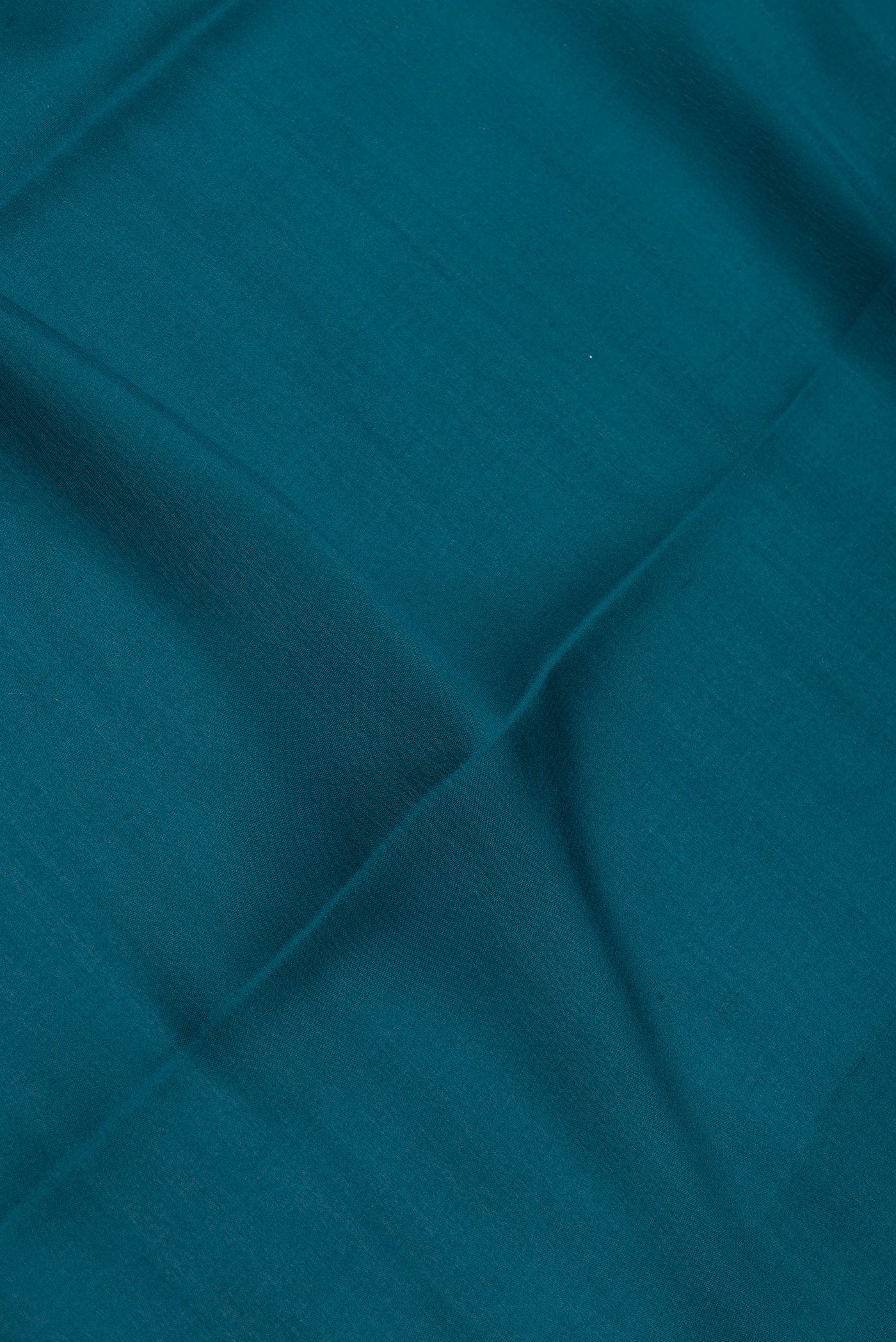 Close up of Peacock Blue Mysore Silk Saree with Plain Body and Zari Border.  displaying folds