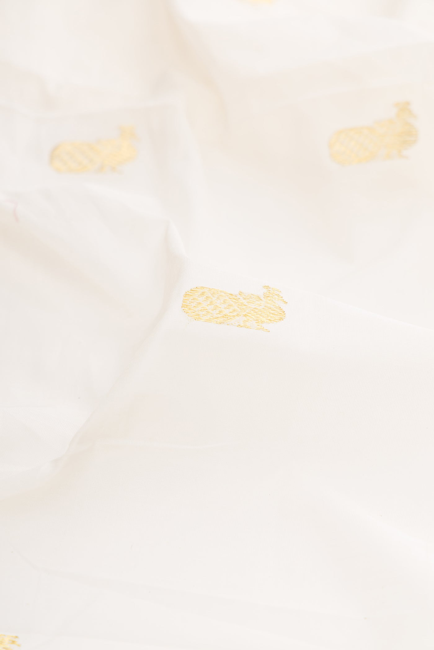 Close up of White Kerala Cotton Saree with Zari Butta on the body and Temple Border.  displaying folds
