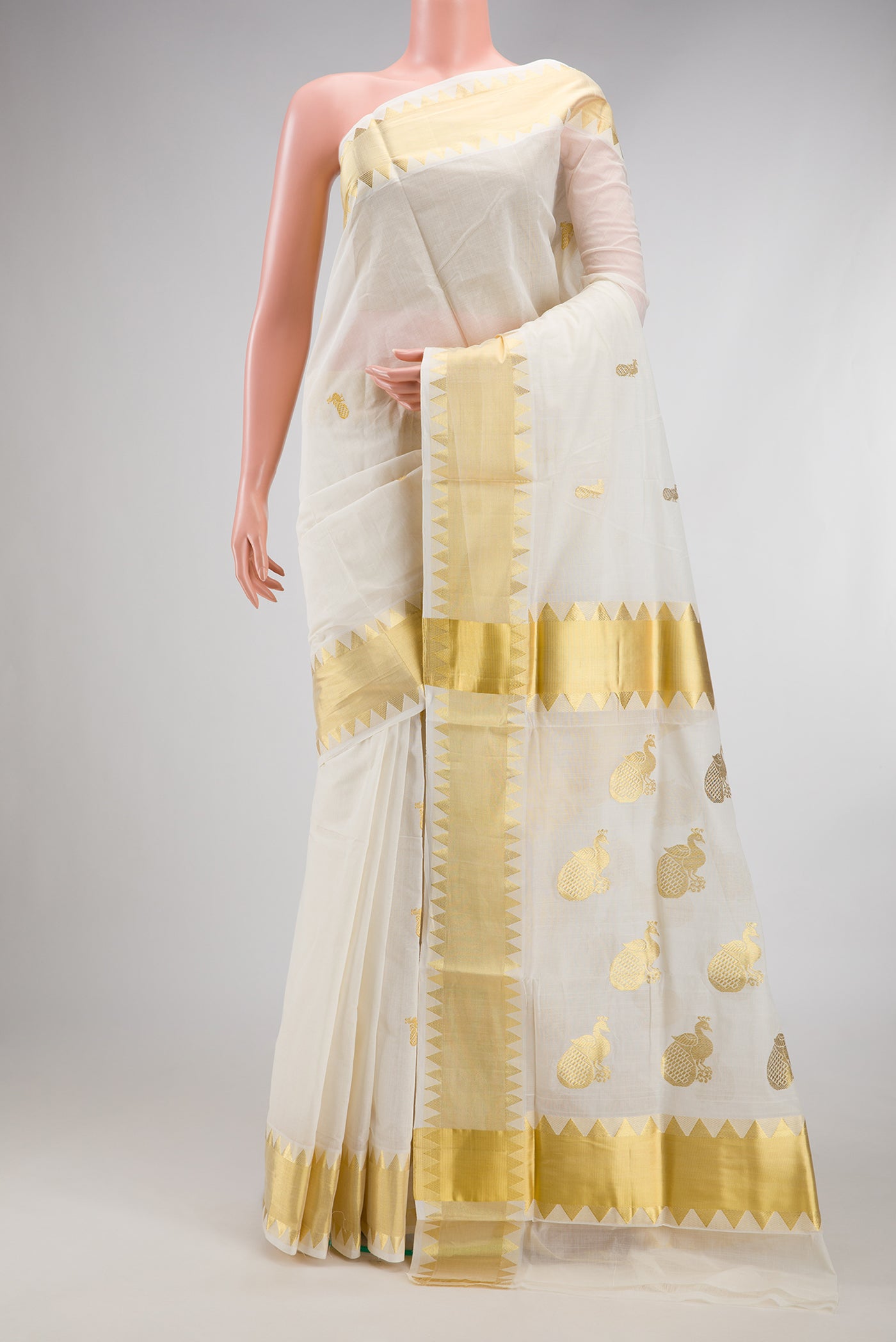 White Kerala Cotton Saree with Zari Butta on the body and Temple Border.  displayed on a mannequin