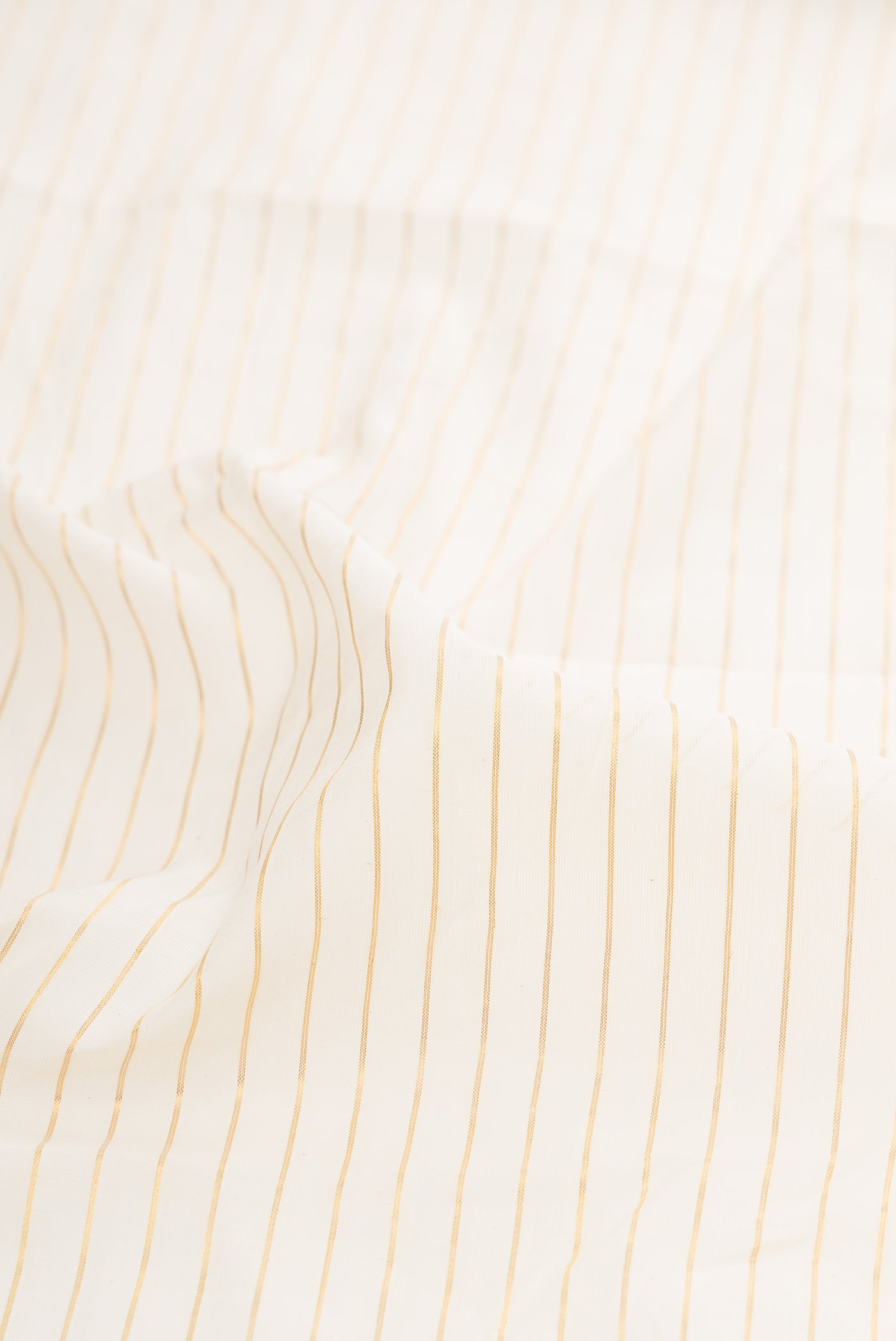 Close up of Off White Kerala Cotton Saree with Stripes on the body and Fancy Border.  displaying folds