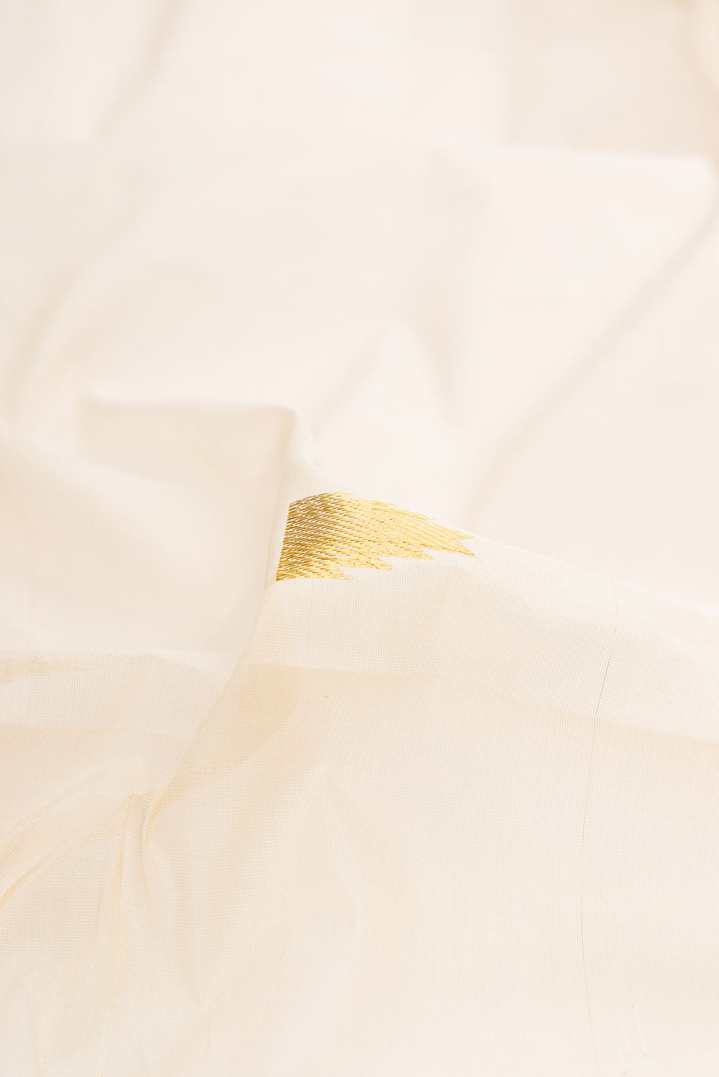 Close up of Pure Silk Off White Kerala Cotton Saree with Zari Butta on the body and Zari Border.  displaying folds