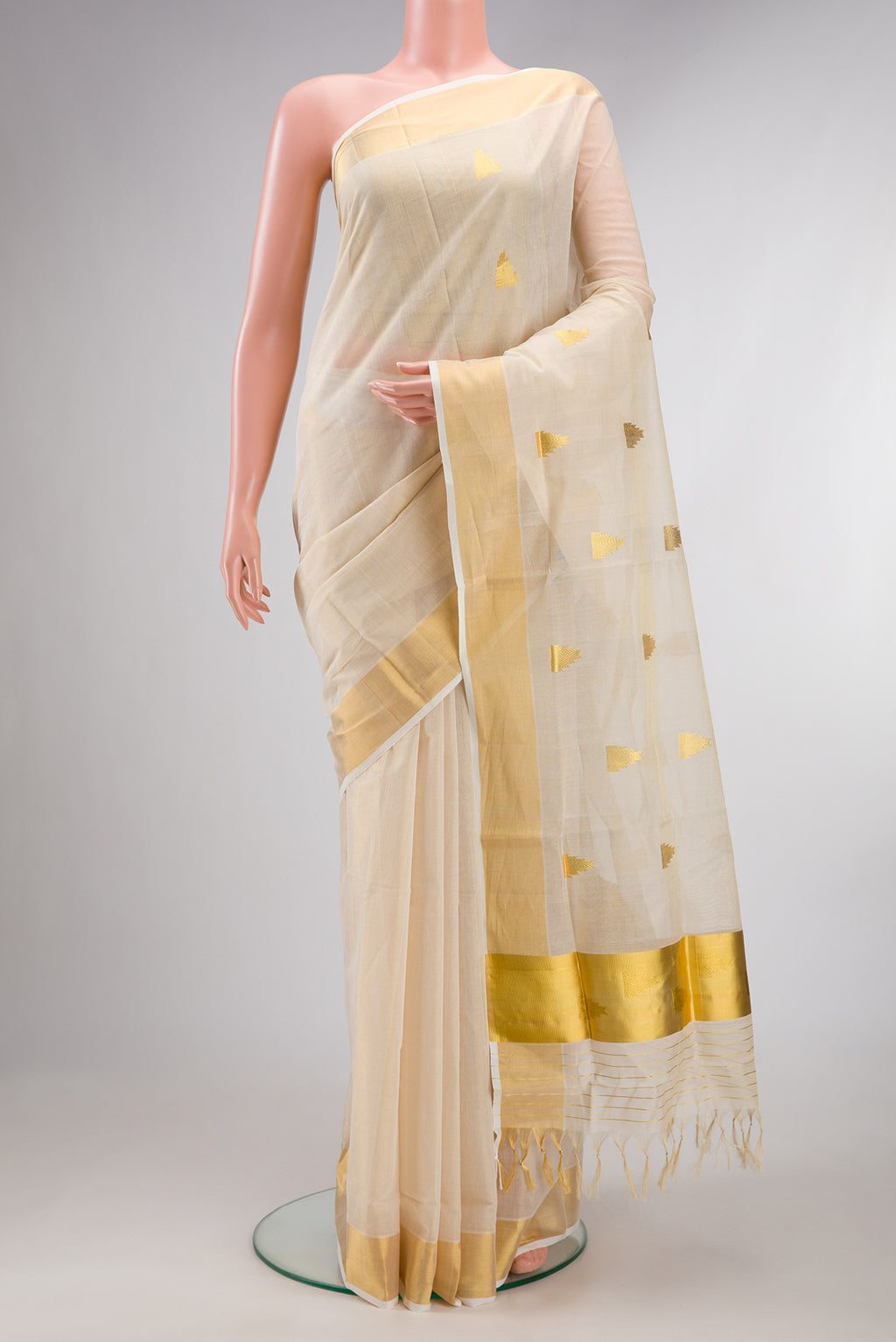 Pure Silk Off White Kerala Cotton Saree with Zari Butta on the body and Zari Border.  displayed on a mannequin