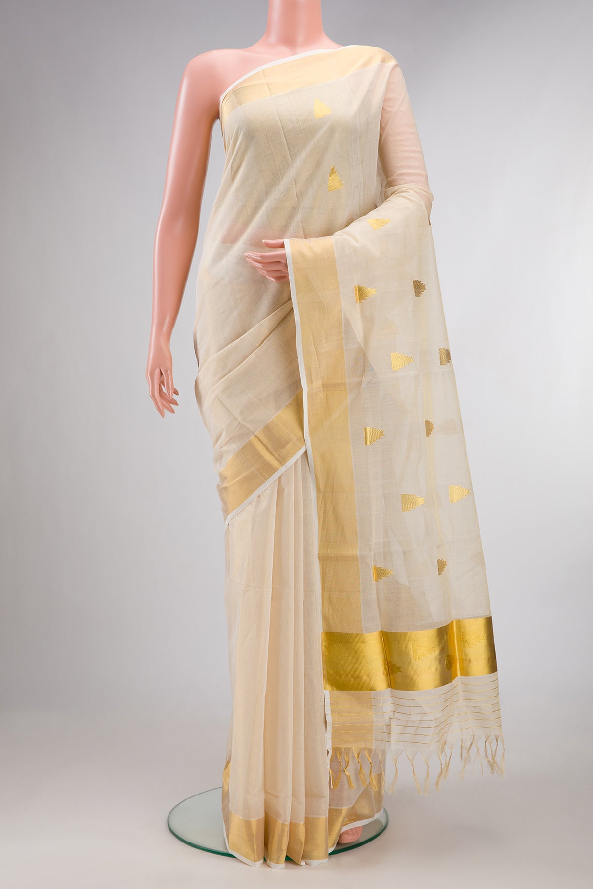 Pure Silk Off White Kerala Cotton Saree with Zari Butta on the body and Zari Border.  displayed on a mannequin