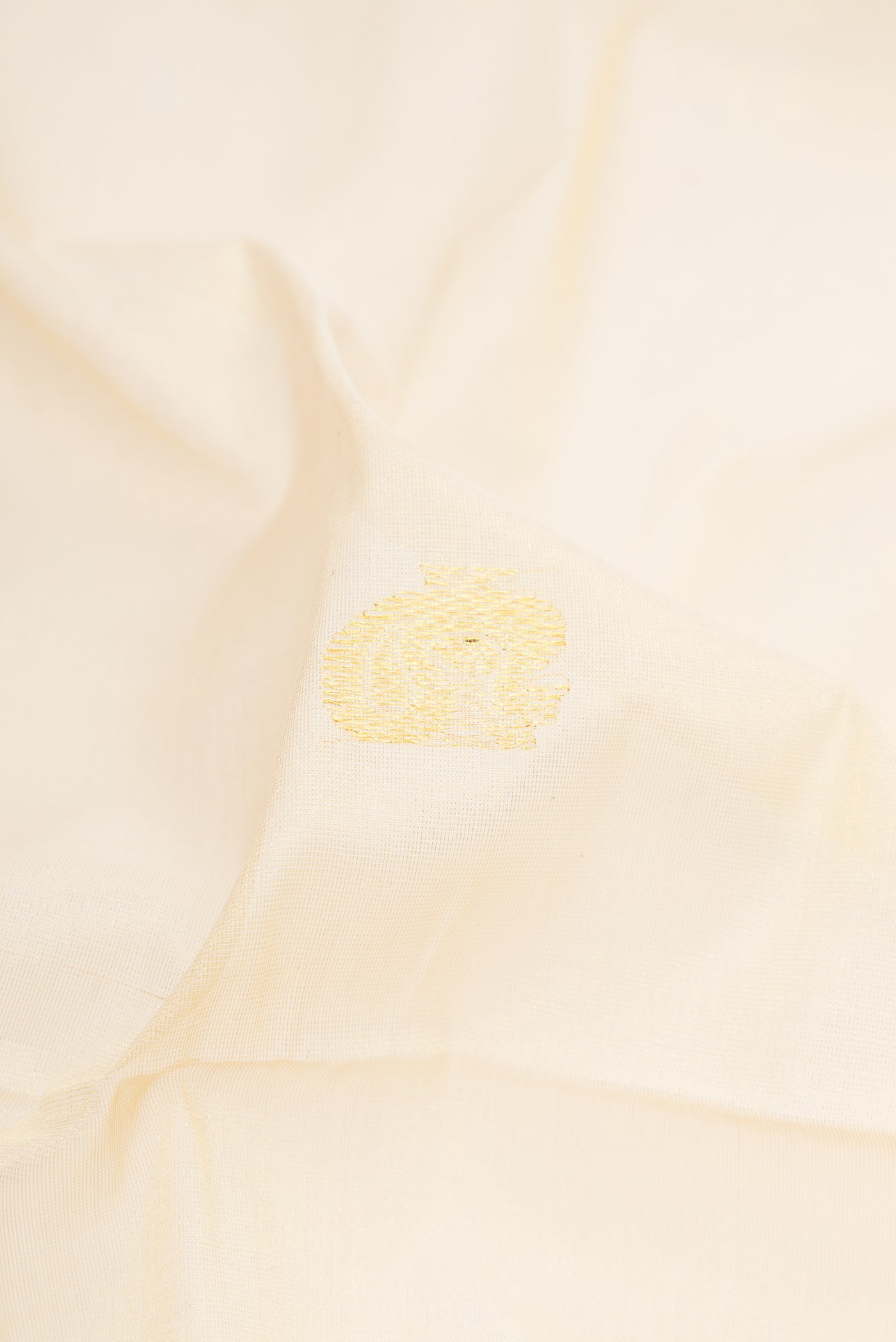 Close up of Gold Kerala Cotton Saree with Zari Butta on the body and Zari Border.  displaying folds