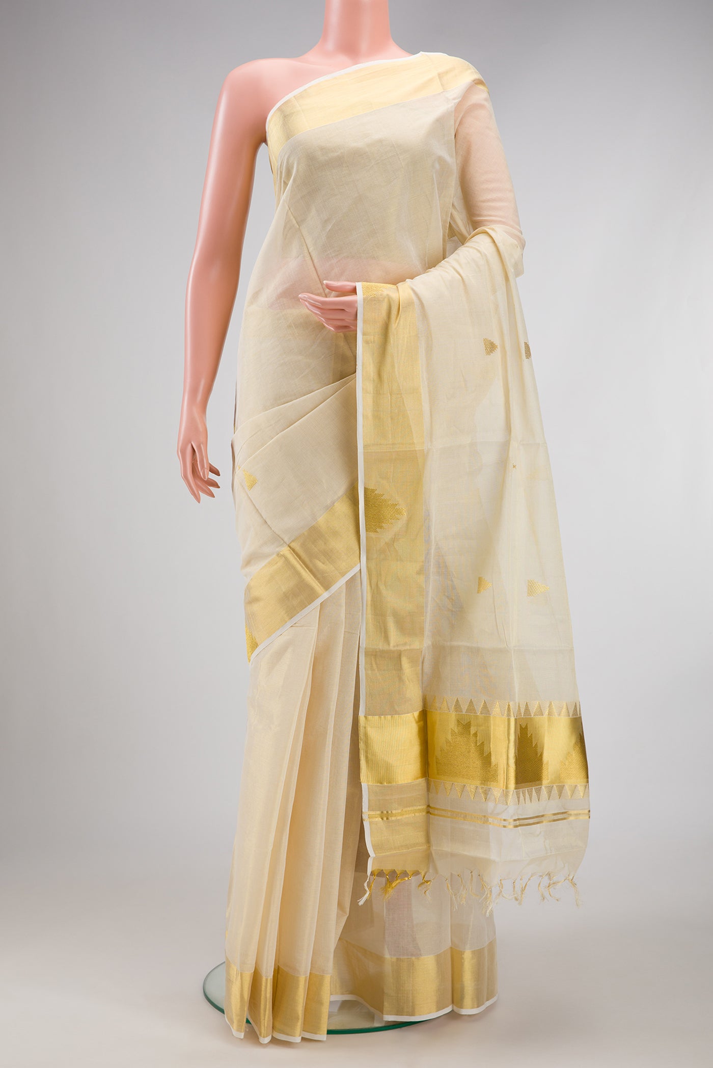 Off White Kerala Cotton Saree with Zari Butta on the body and Zari Border.  displayed on a mannequin