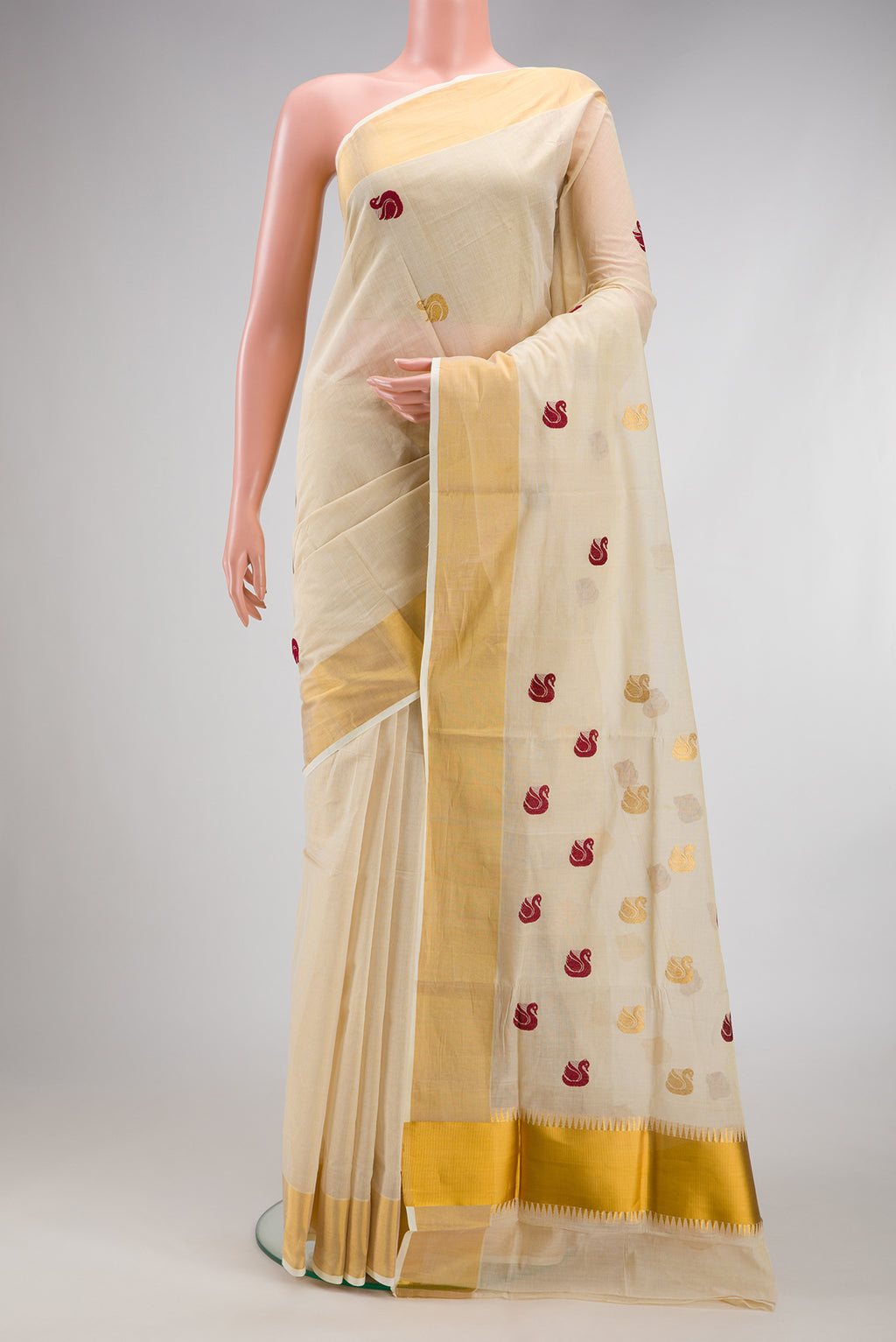 Off White Kerala Cotton Saree with Zari And Thread Butta on the body and Zari Border.  displayed on a mannequin
