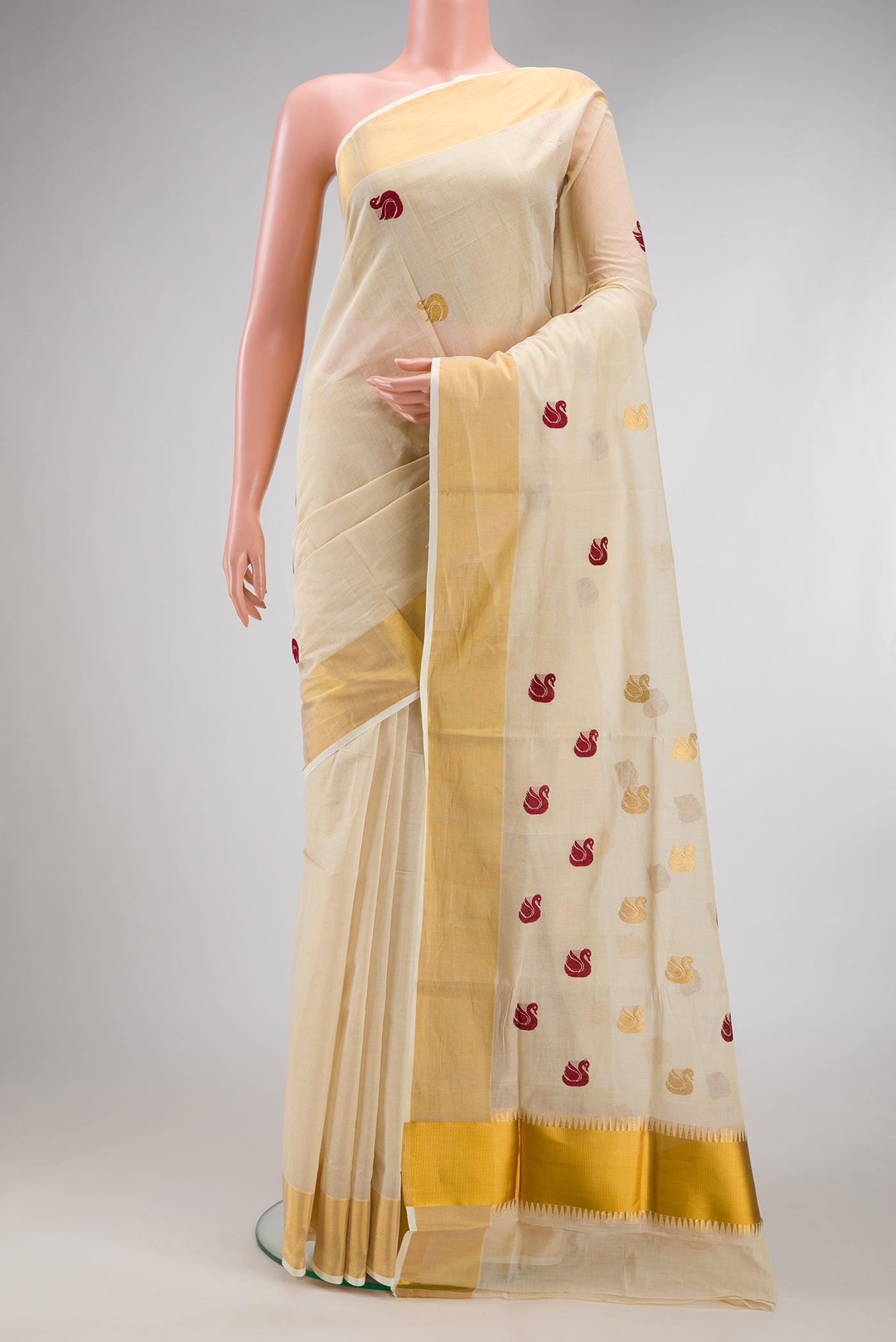 Off White Kerala Cotton Saree with Zari And Thread Butta on the body and Zari Border.  displayed on a mannequin