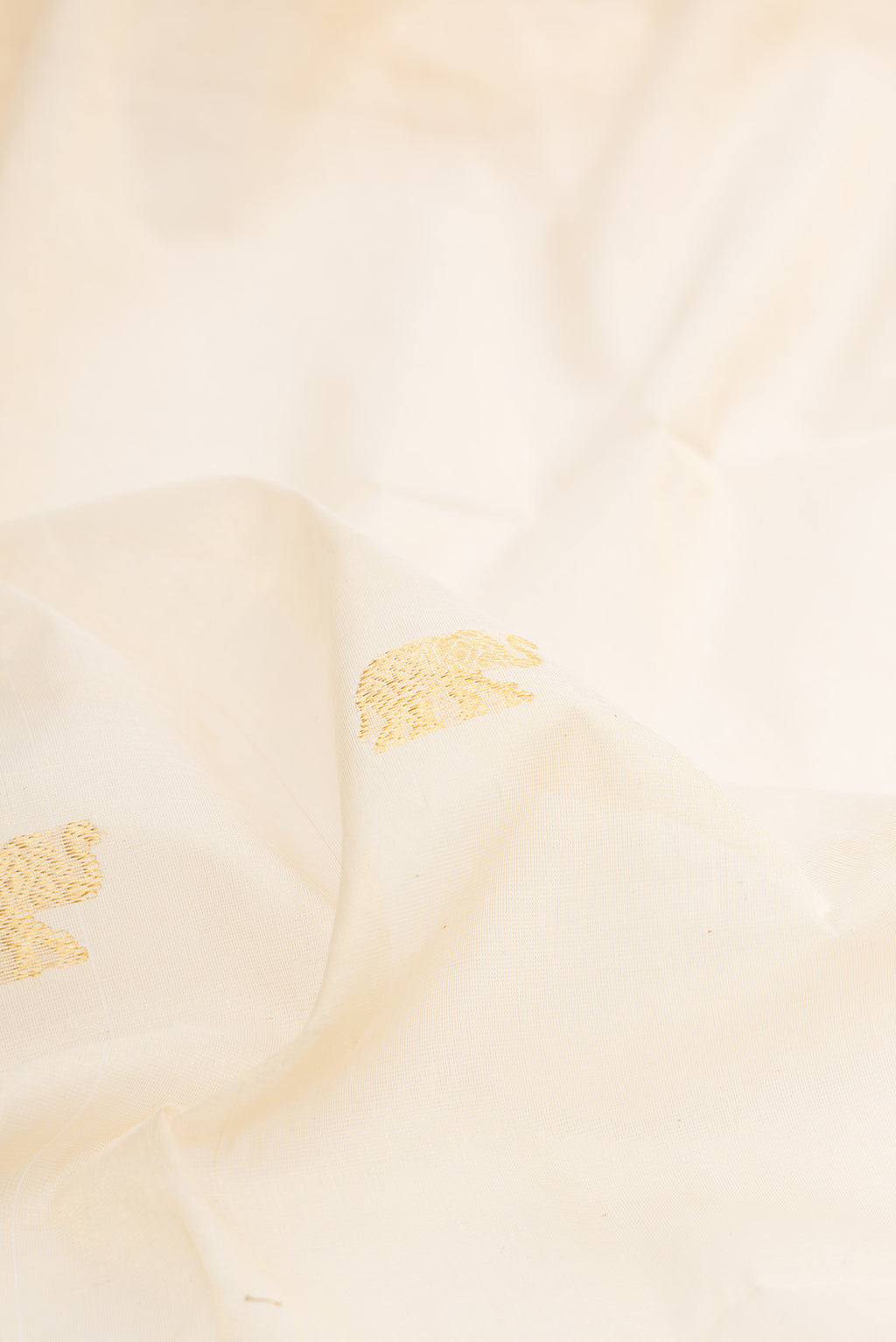 Close up of Pure Silk Off White Kerala Cotton Saree with Zari Butta on the body and Zari Border.  displaying folds