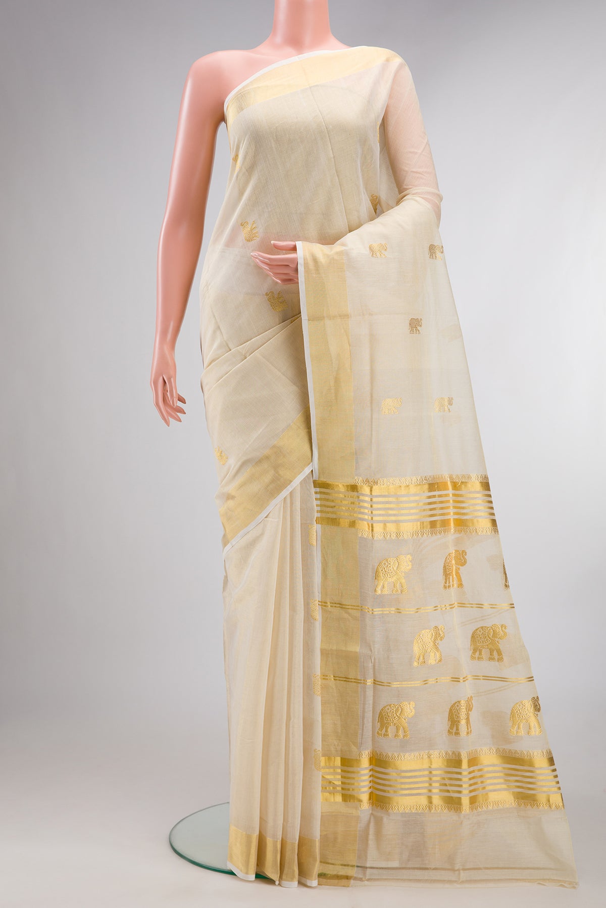 Pure Silk Off White Kerala Cotton Saree with Zari Butta on the body and Zari Border.  displayed on a mannequin