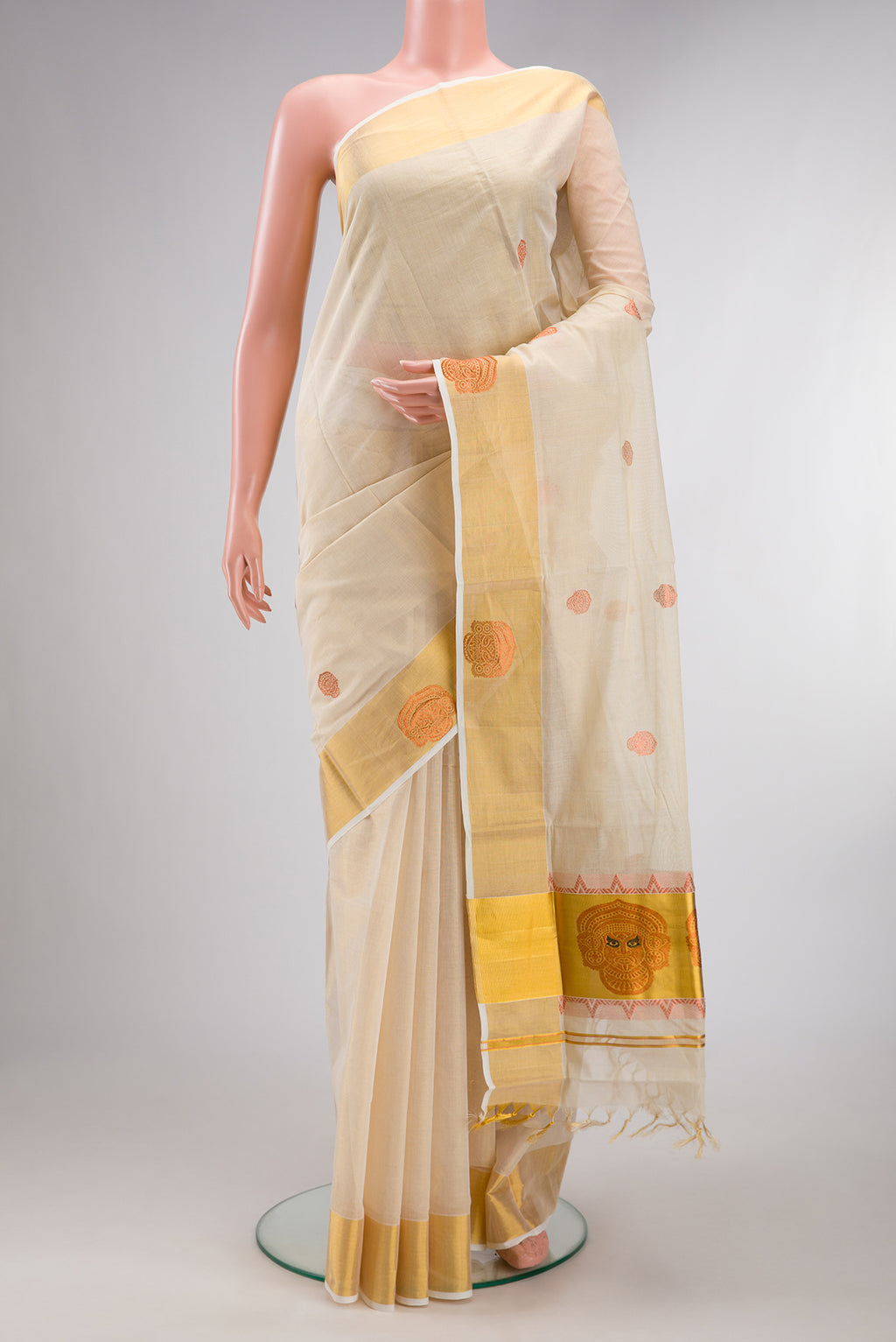 Pure Silk Off White Kerala Cotton Saree with Zari Butta on the body and Fancy Border.  displayed on a mannequin