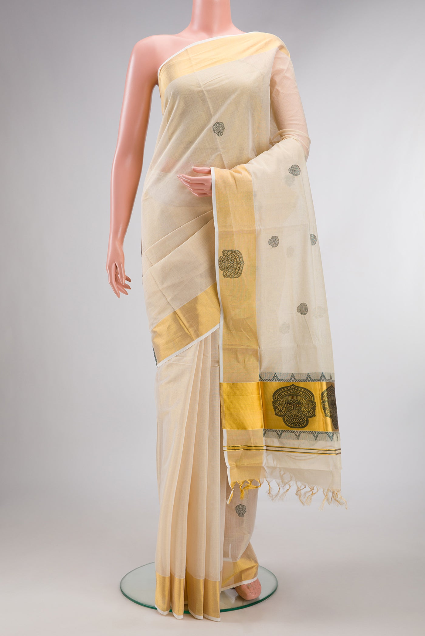 Pure Silk Off White Kerala Cotton Saree with Thread Butta on the body and Zari Border.  displayed on a mannequin