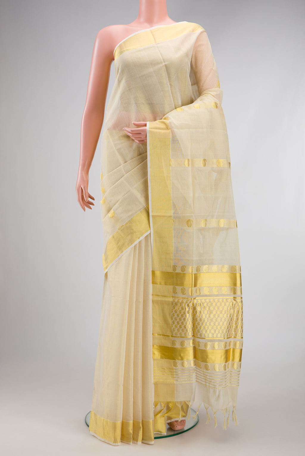 Off White Kerala Cotton Saree with Zari Butta on the body and Zari Border.  displayed on a mannequin
