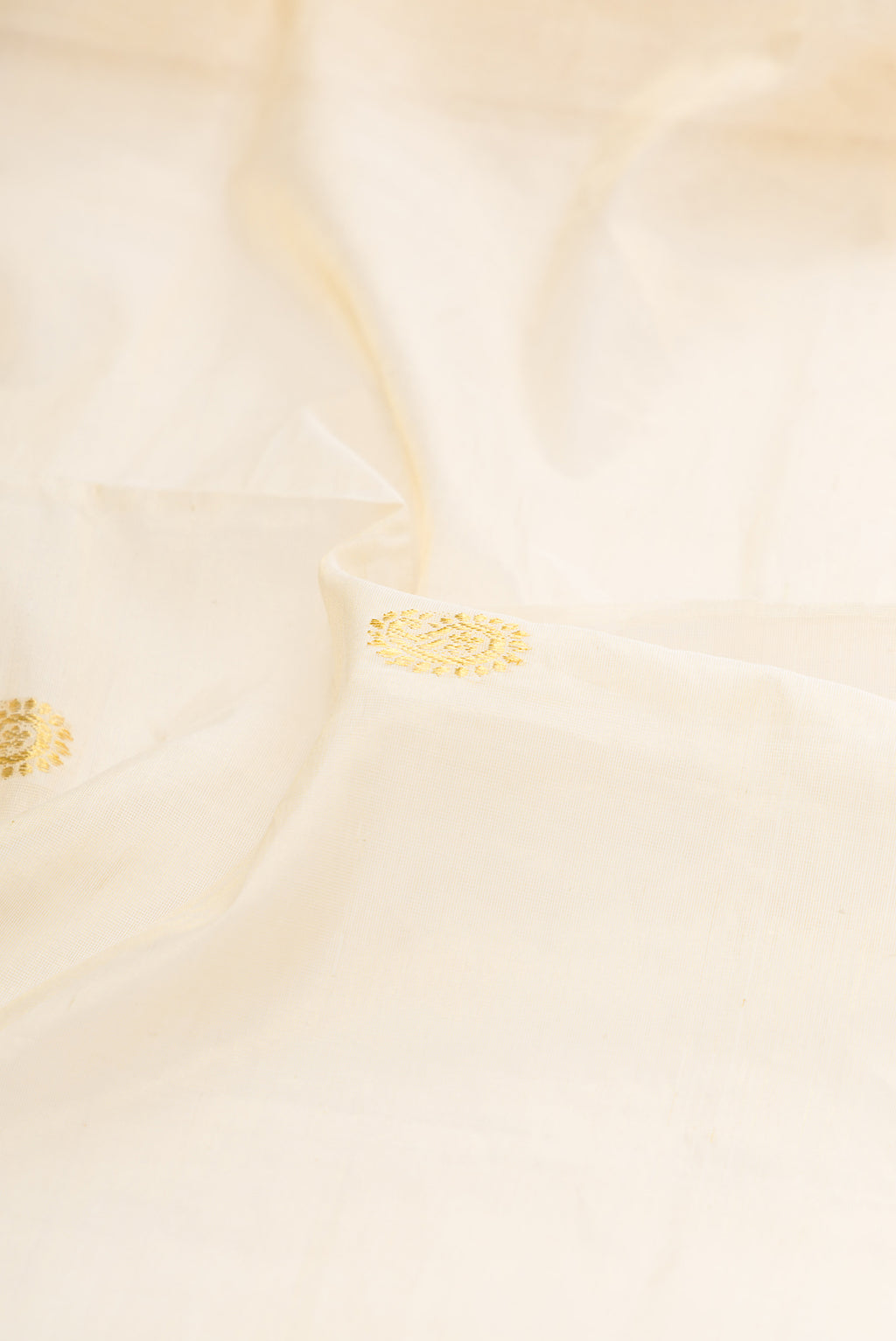 Close up of Pure Silk Off White Kerala Cotton Saree with Zari Butta on the body and Zari Border.  displaying folds