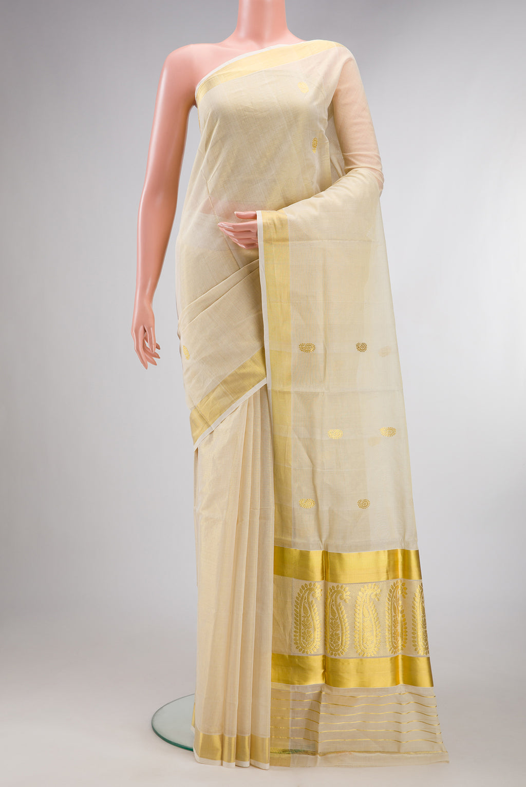 Pure Silk Off White Kerala Cotton Saree with Zari Butta on the body and Zari Border.  displayed on a mannequin