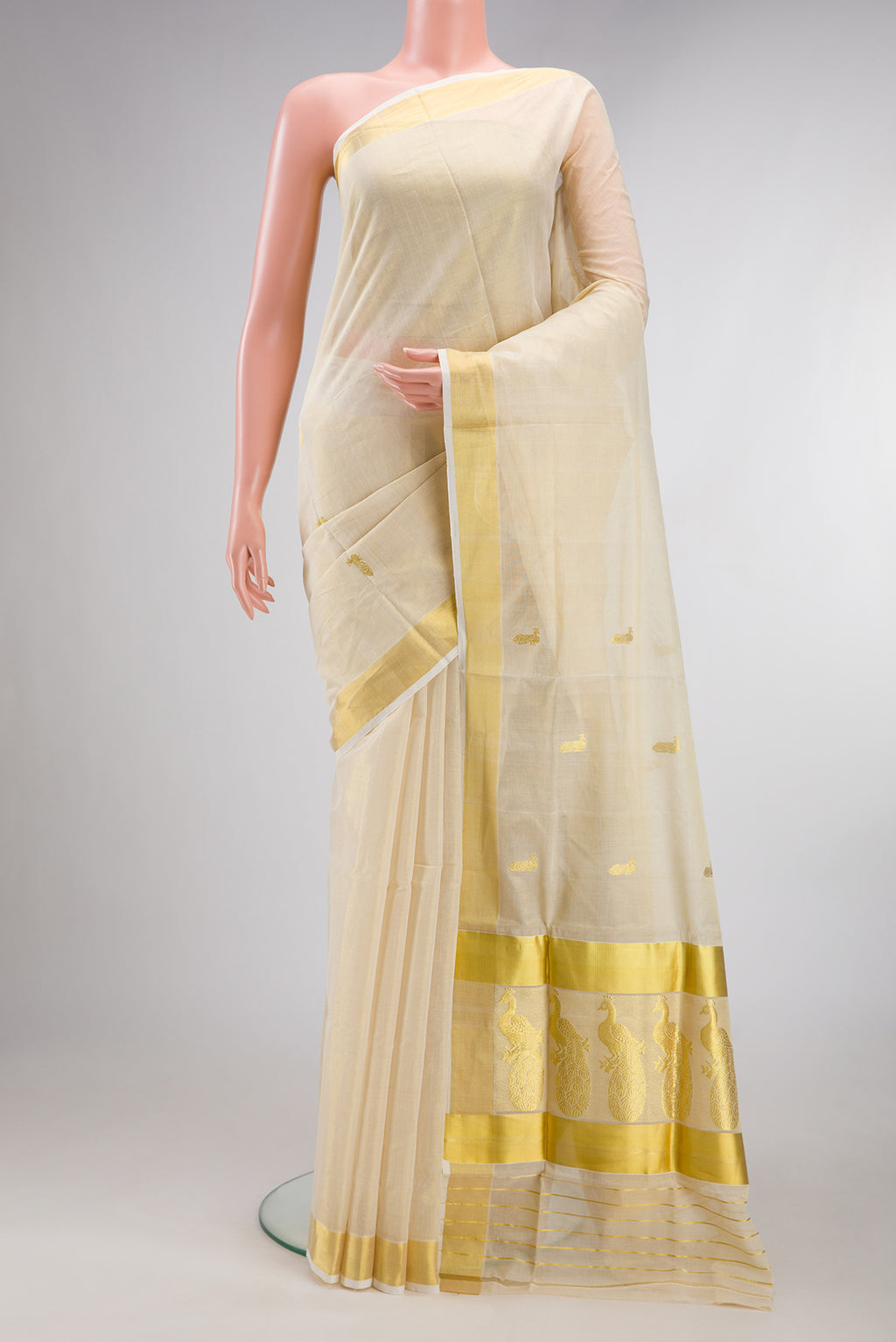 Pure Silk Off White Kerala Cotton Saree with Zari Butta on the body and Zari Border.  displayed on a mannequin
