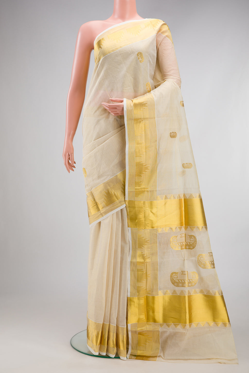 Off White Kerala Cotton Saree with Zari Butta on the body and Temple Border.  displayed on a mannequin