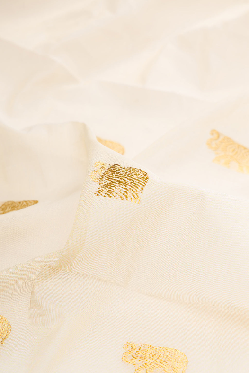 Close up of Pure Silk Off White Kerala Cotton Saree with Zari Butta on the body and Zari Border.  displaying folds