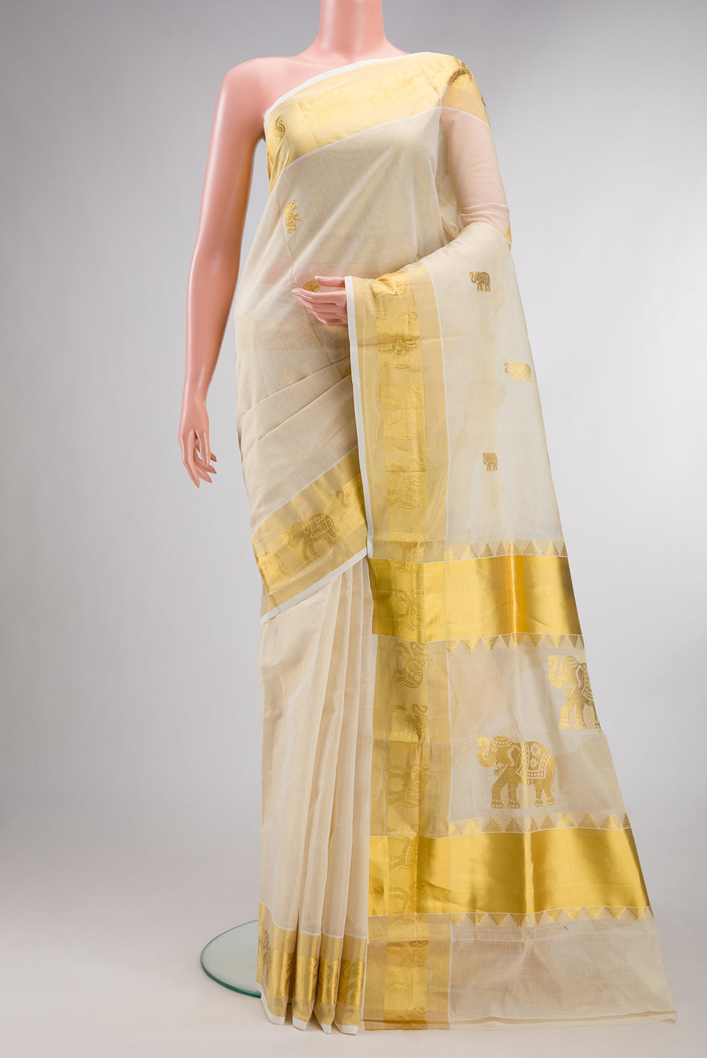 Pure Silk Off White Kerala Cotton Saree with Zari Butta on the body and Zari Border.  displayed on a mannequin