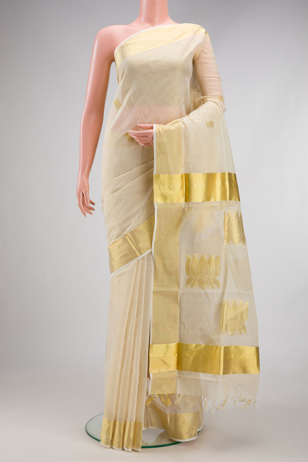 Off White Kerala Cotton Saree with Zari Butta on the body and Zari Border.  displayed on a mannequin