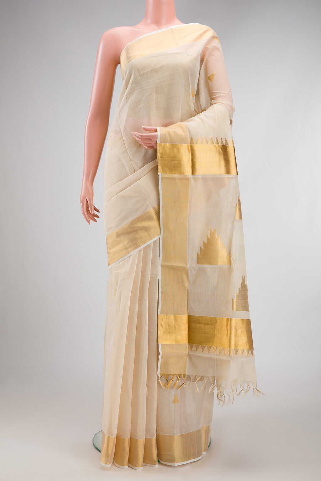 Off White Kerala Cotton Saree with Zari Butta on the body and Zari Border.  displayed on a mannequin