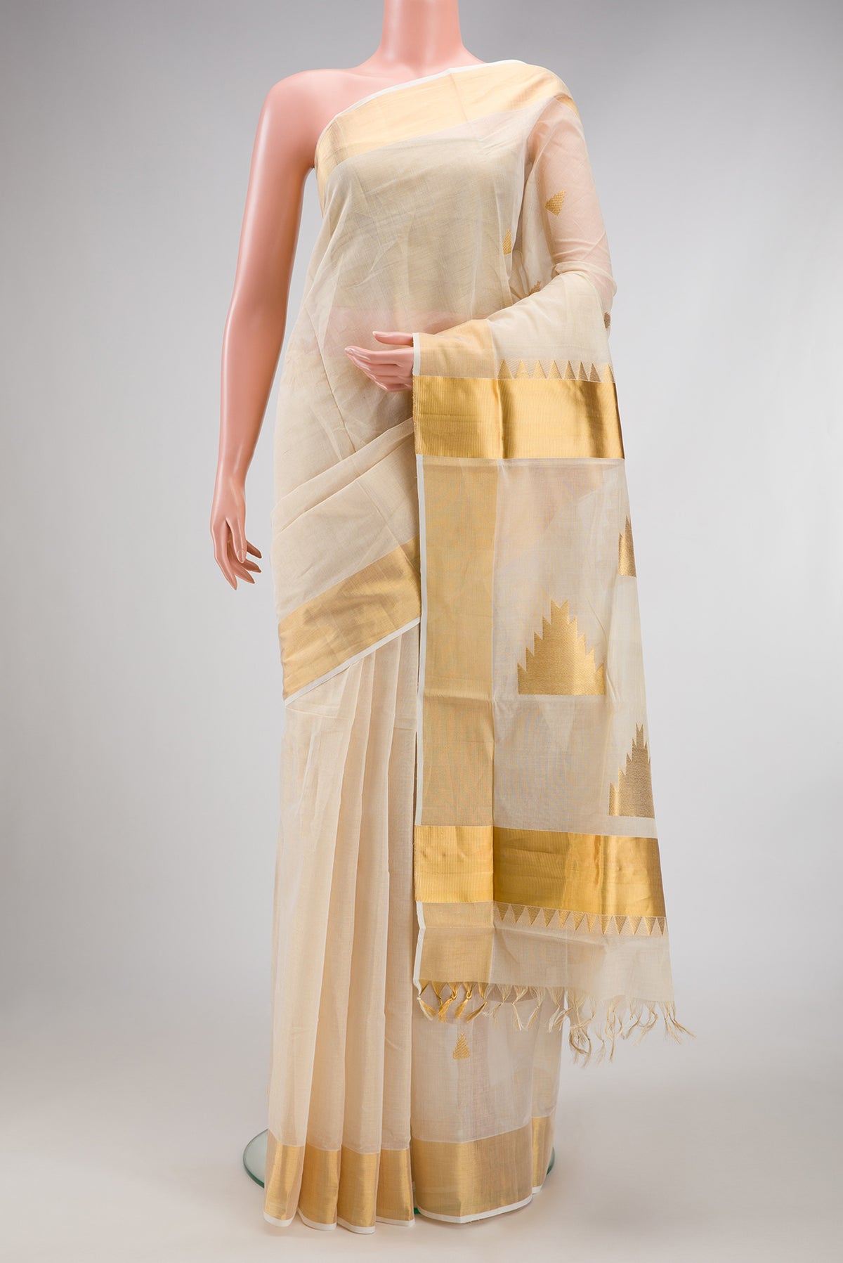 Off White Kerala Cotton Saree with Zari Butta on the body and Zari Border.  displayed on a mannequin
