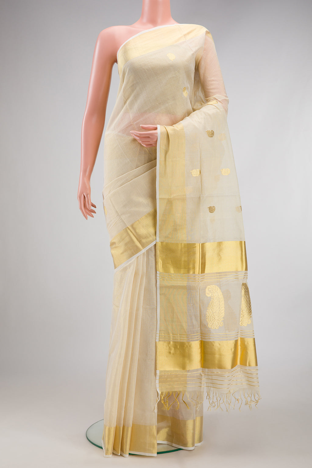 Off White Kerala Cotton Saree with Zari Butta on the body and Zari Border.  displayed on a mannequin