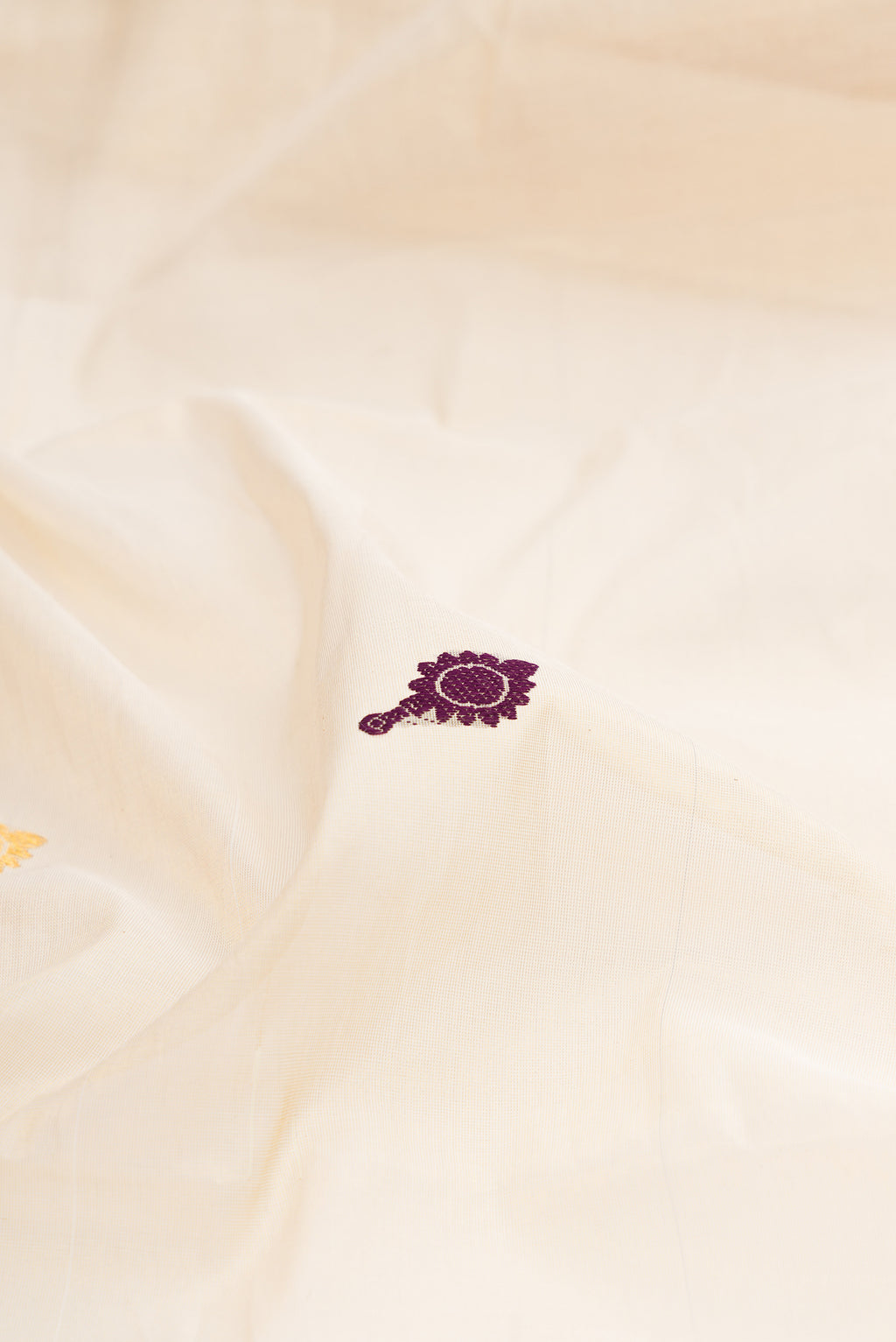Close up of Off White Kerala Cotton Saree with Zari And Thread Butta on the body and Zari Border.  displaying folds