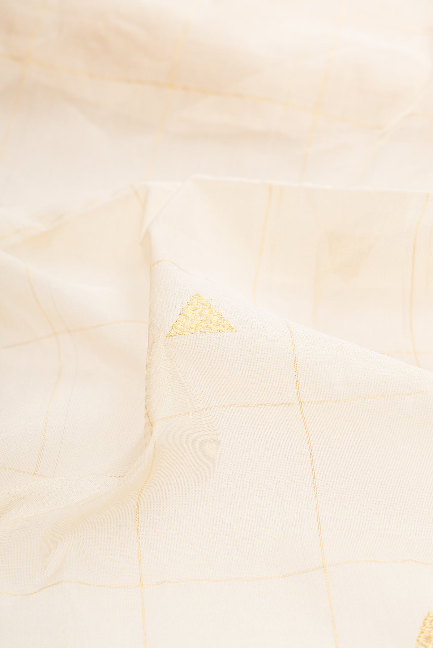Close up of Off White Kerala Cotton Saree with Checked design on the body and Zari Border.  displaying folds
