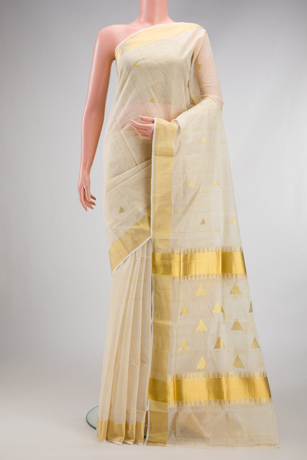 Off White Kerala Cotton Saree with Checked design on the body and Zari Border.  displayed on a mannequin