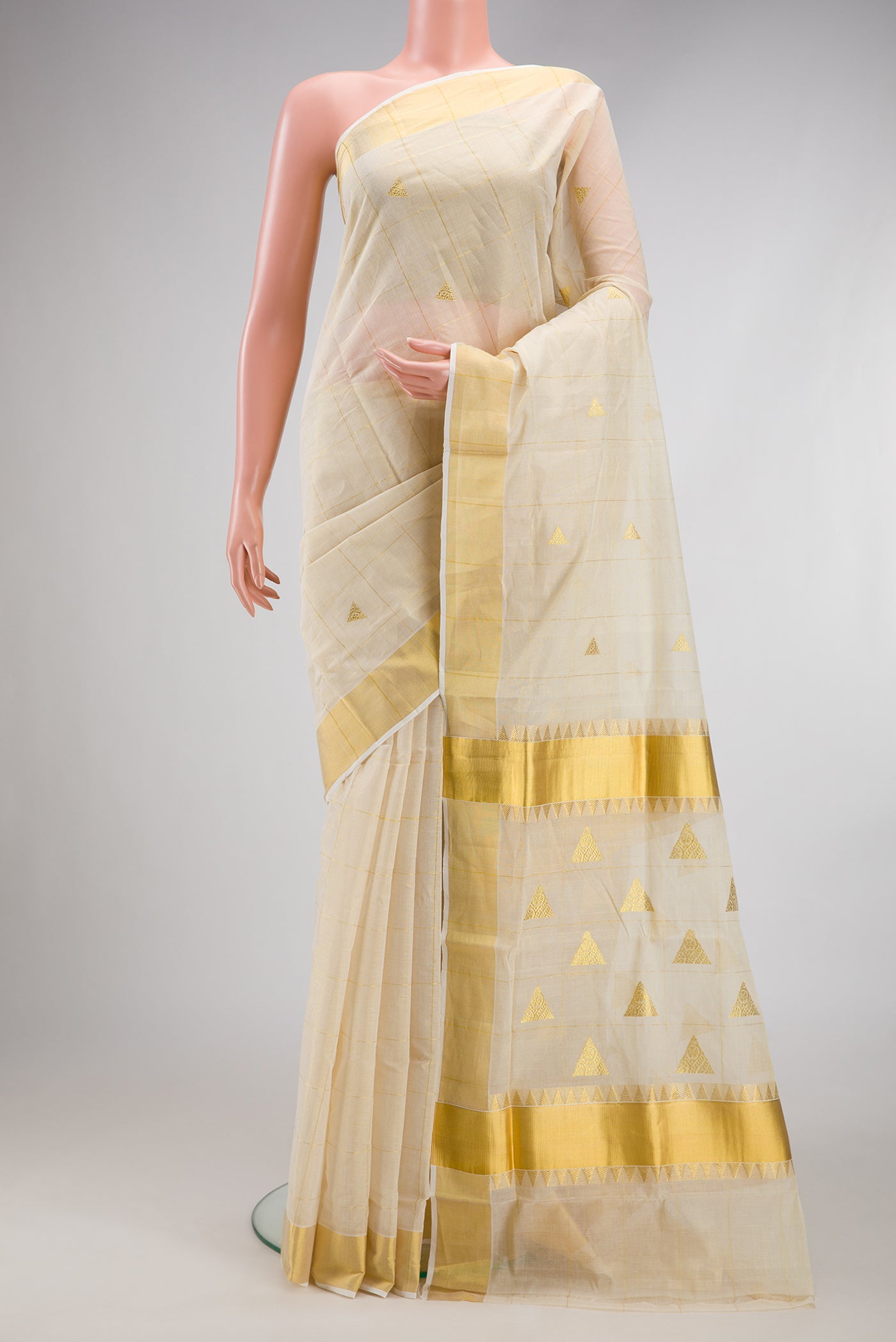 Off White Kerala Cotton Saree with Checked design on the body and Zari Border.  displayed on a mannequin