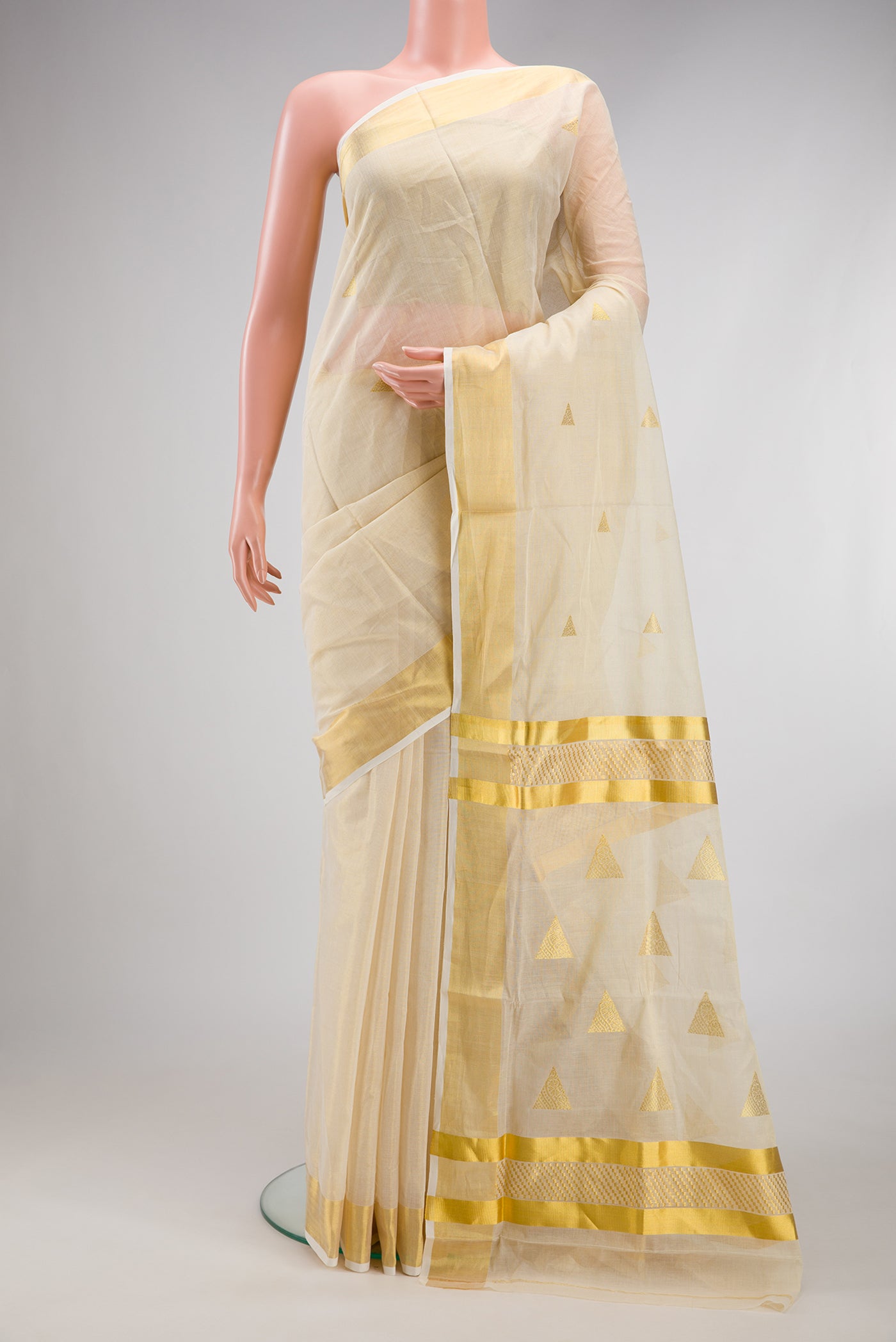 Off White Kerala Cotton Saree with Zari Butta on the body and Zari Border.  displayed on a mannequin