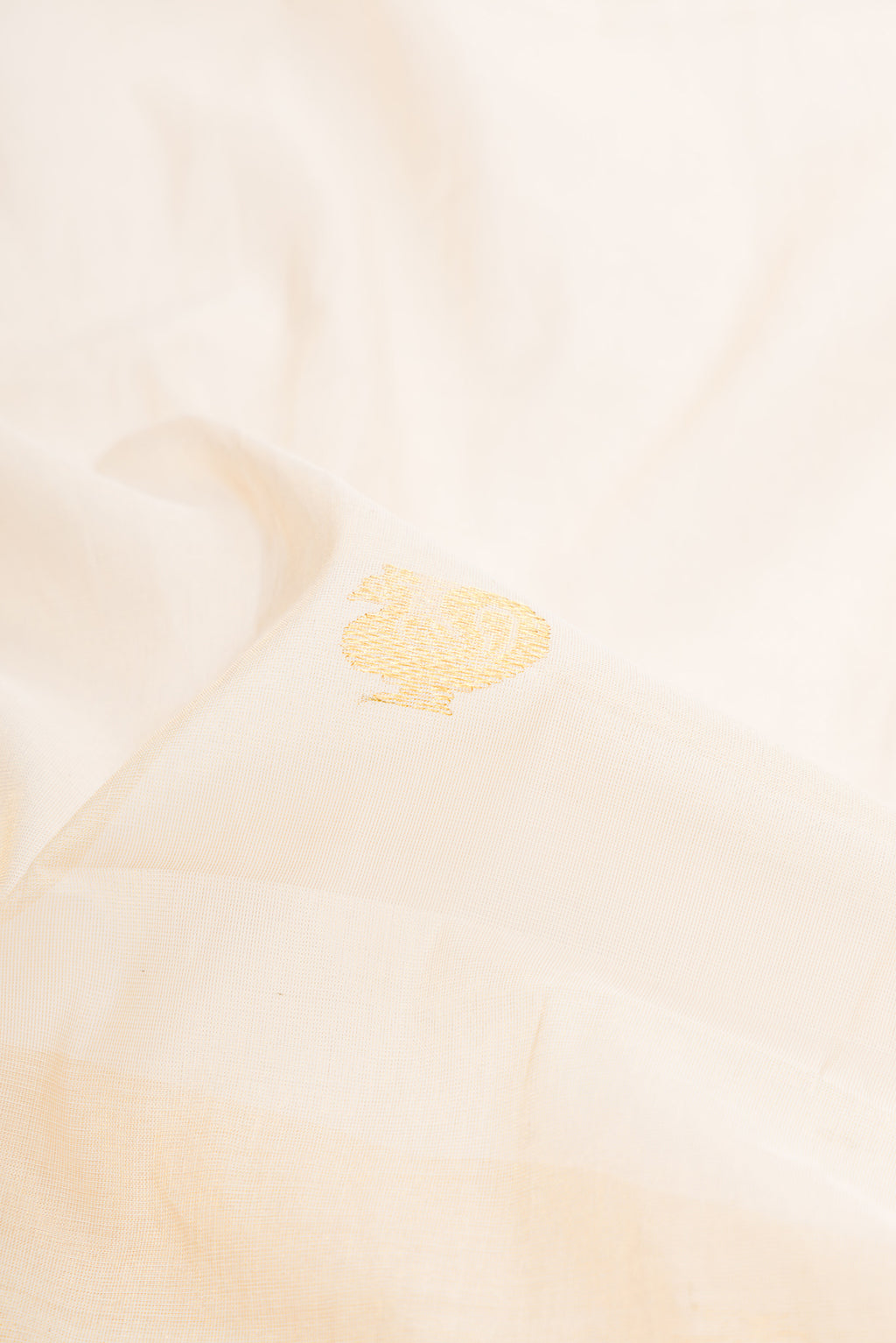Close up of Off White Kerala Cotton Saree with Zari Butta on the body and Fancy Border.  displaying folds