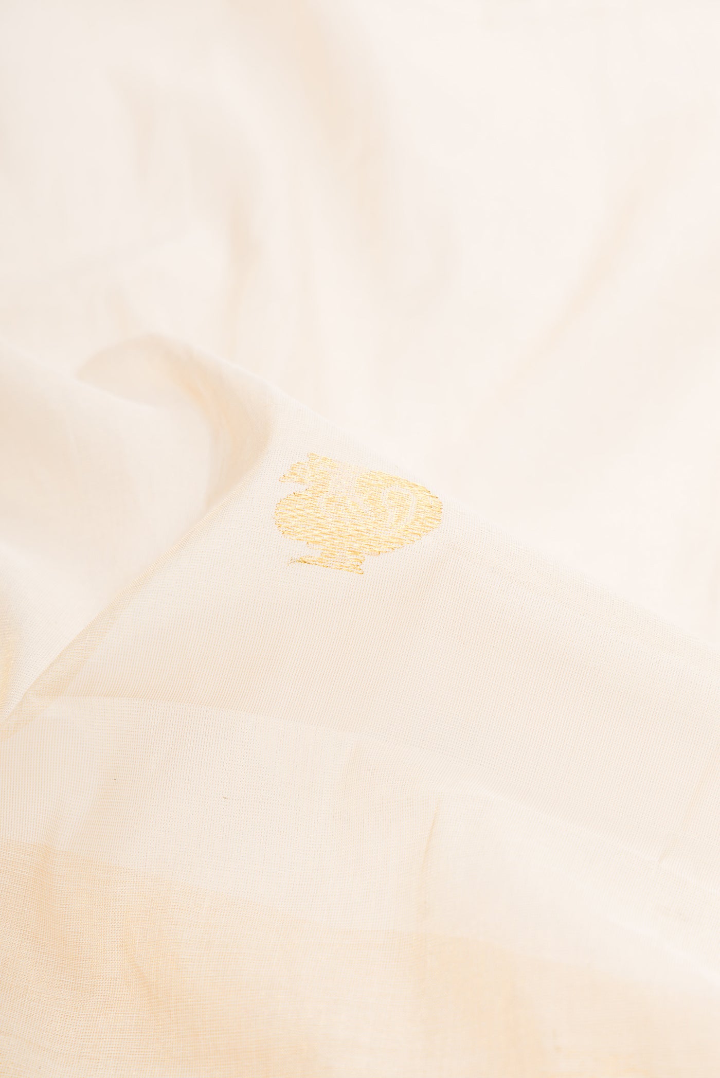 Close up of Off White Kerala Cotton Saree with Zari Butta on the body and Fancy Border.  displaying folds