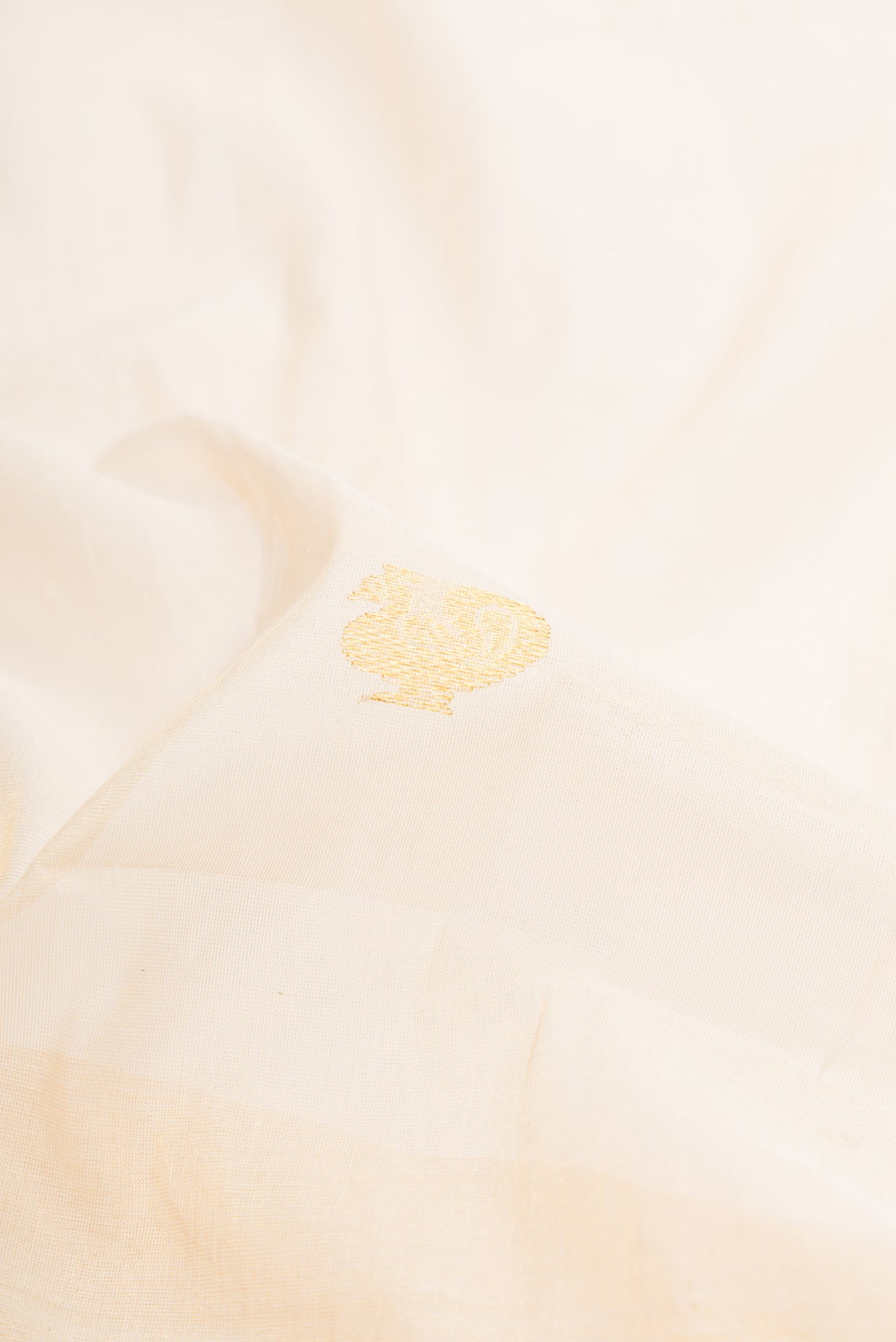 Close up of Off White Kerala Cotton Saree with Zari Butta on the body and Fancy Border.  displaying folds