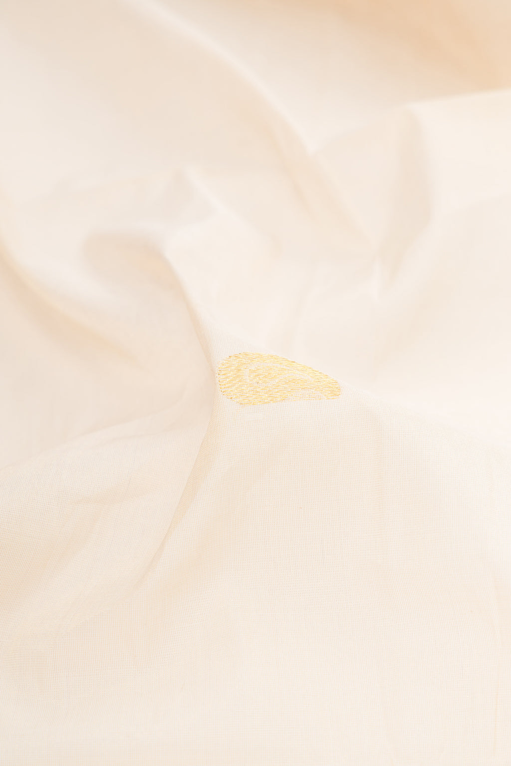 Close up of Off White Kerala Cotton Saree with Zari Butta on the body and Without Border.  displaying folds