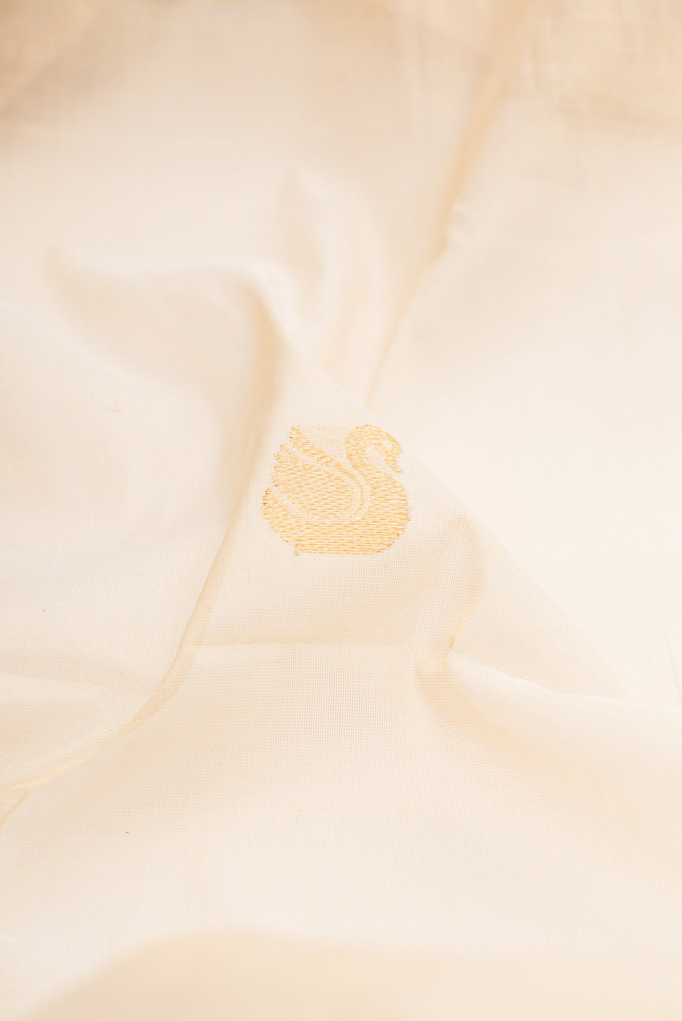 Close up of Off White Kerala Cotton Saree with Zari Butta on the body and Zari Border.  displaying folds