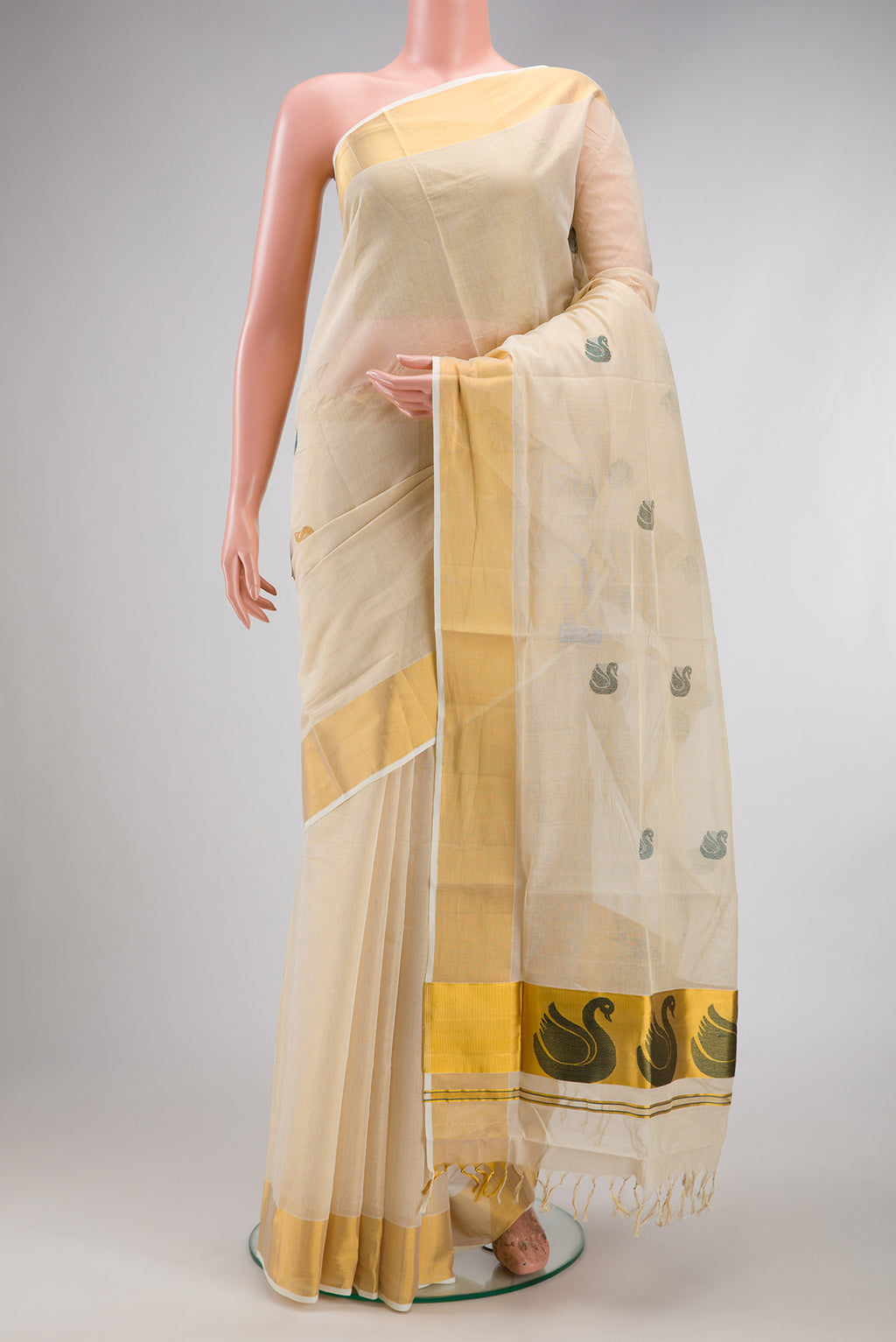 Off White Kerala Cotton Saree with Zari And Thread Butta on the body and Zari Border.  displayed on a mannequin