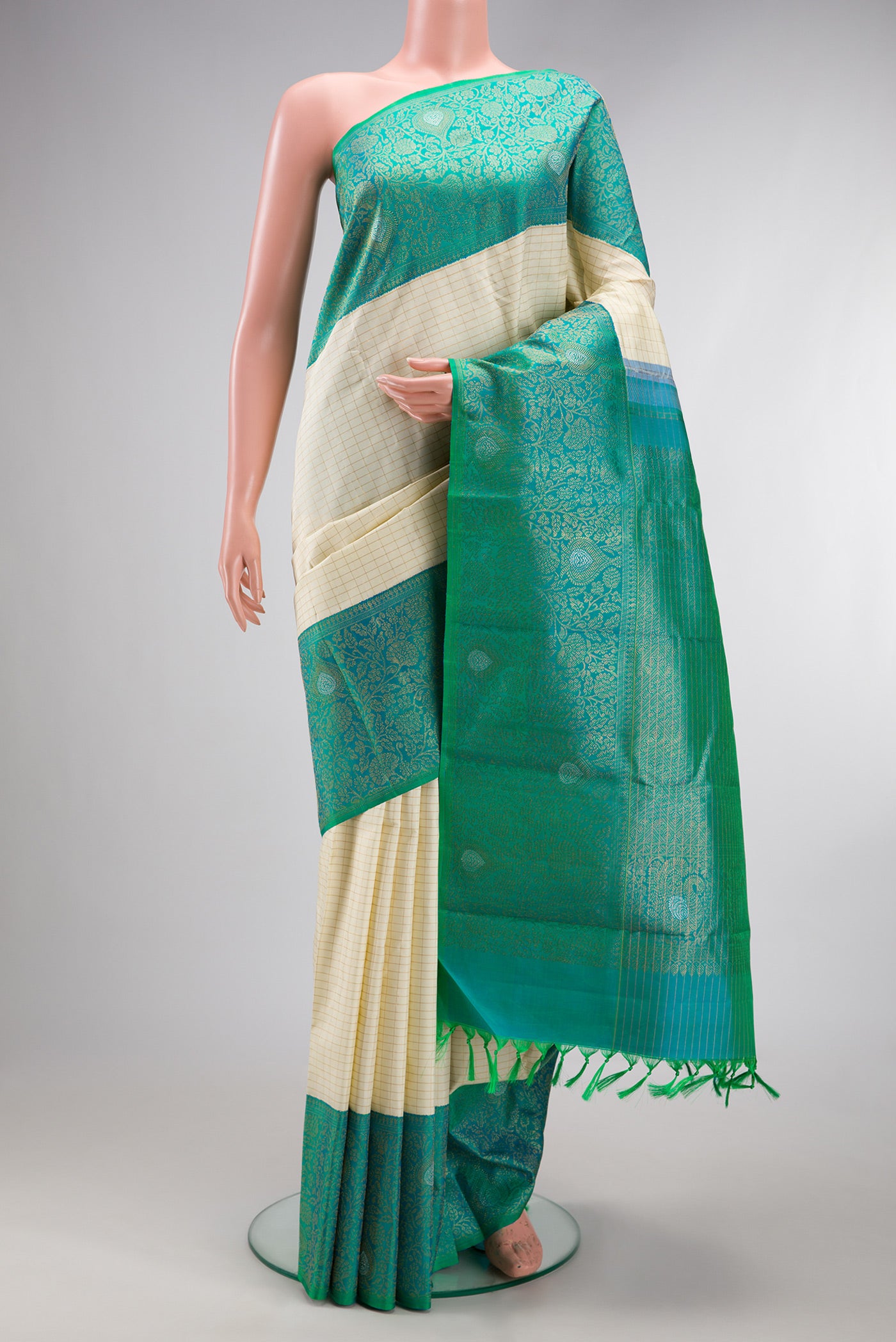 Pure Silk Pure Zari Off White Kanchipuram Saree with Checked design on the body and Zari Border.  displayed on a mannequin