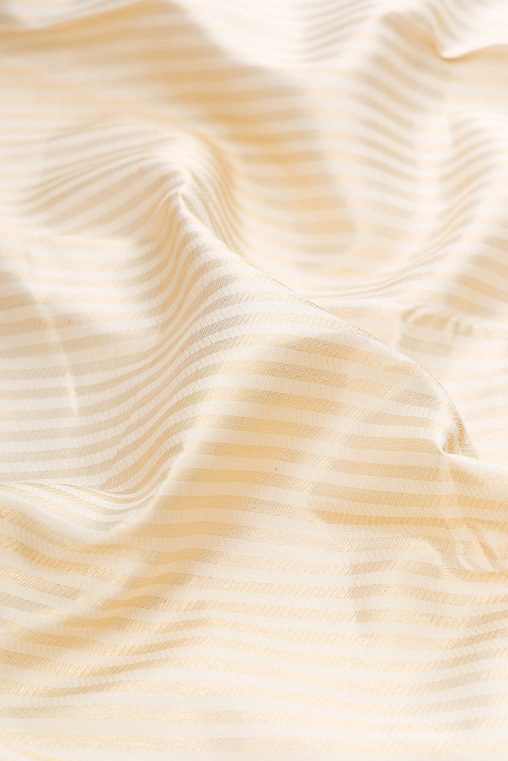 Close up of Off White Kanjivaram Silk Saree with Stripes on the body and Fancy Border.  displaying folds