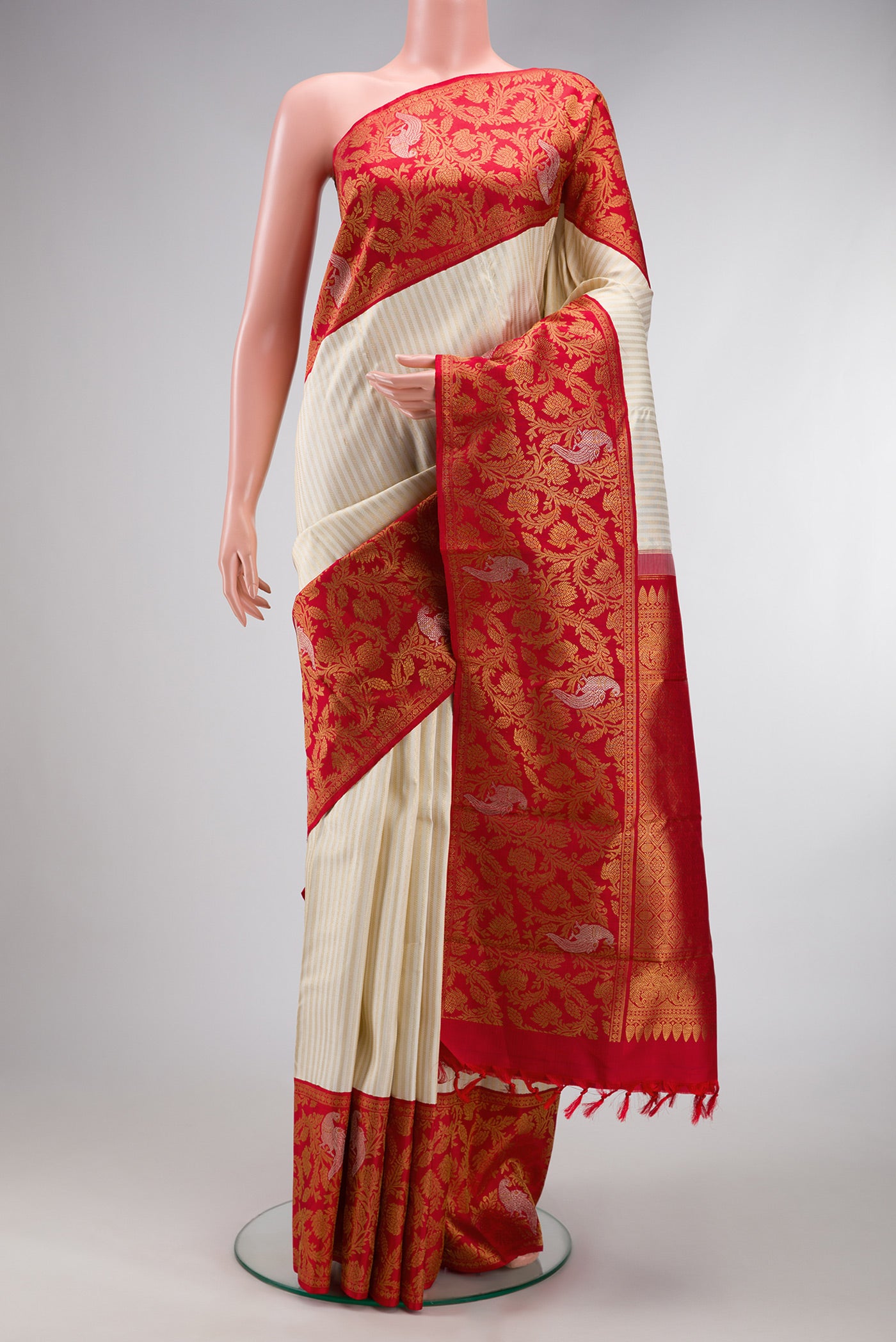 Off White Kanjivaram Silk Saree with Stripes on the body and Fancy Border.  displayed on a mannequin