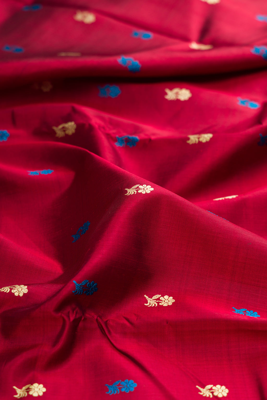 Close up of Maroon Baluchari Silk Saree with Thread Butta on the body and Thread Border.  displaying folds