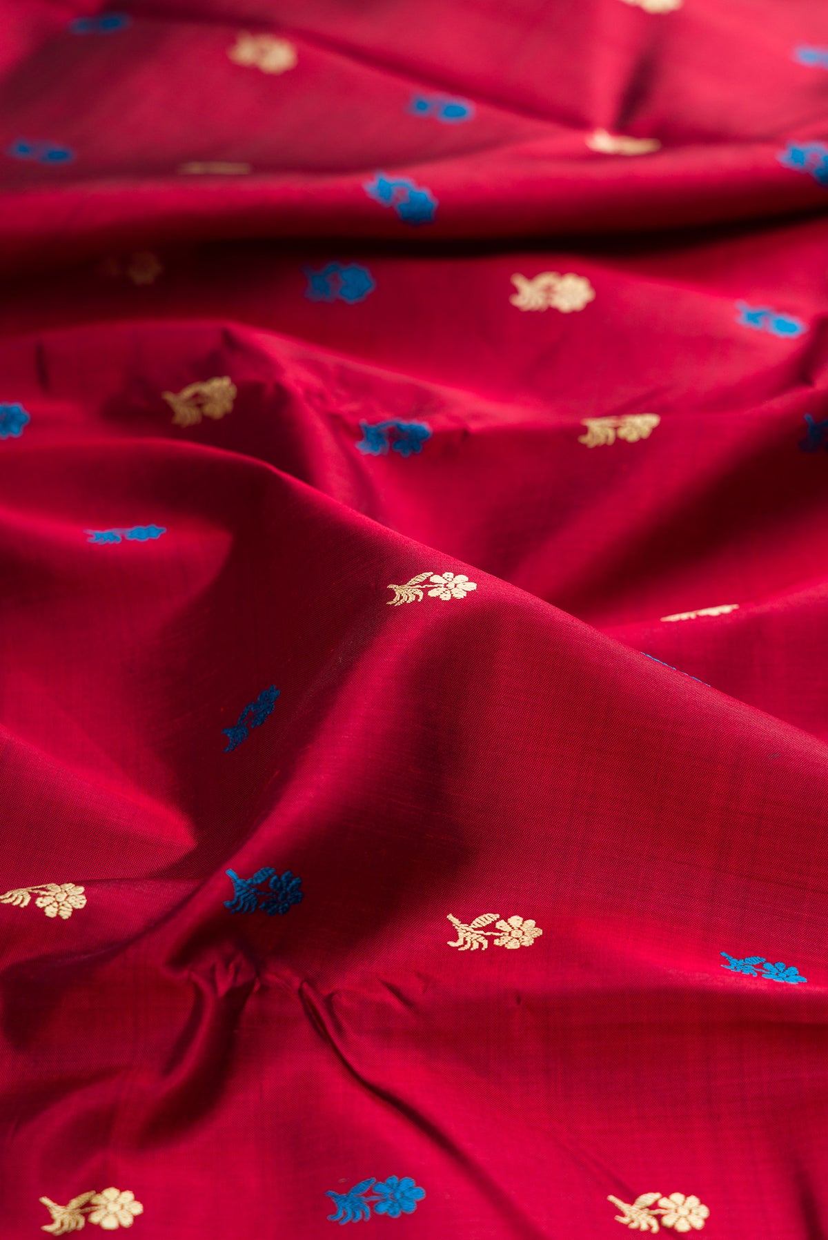 Close up of Maroon Baluchari Silk Saree with Thread Butta on the body and Thread Border.  displaying folds