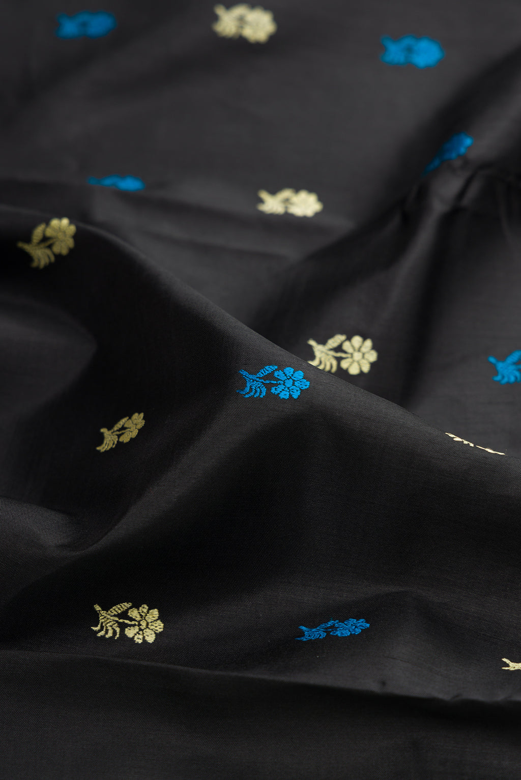 Close up of Black Baluchari Silk Saree with Thread Butta on the body and Thread Border.  displaying folds